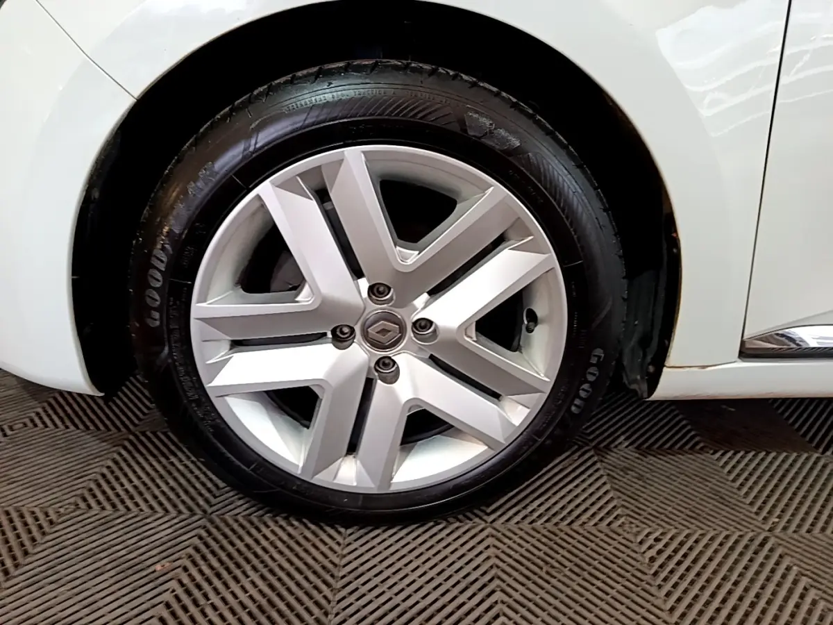 Gros plan sur la roue avant droite blanche d'une Renault Clio Business 2021 avec jante alliage et logo Renault central.