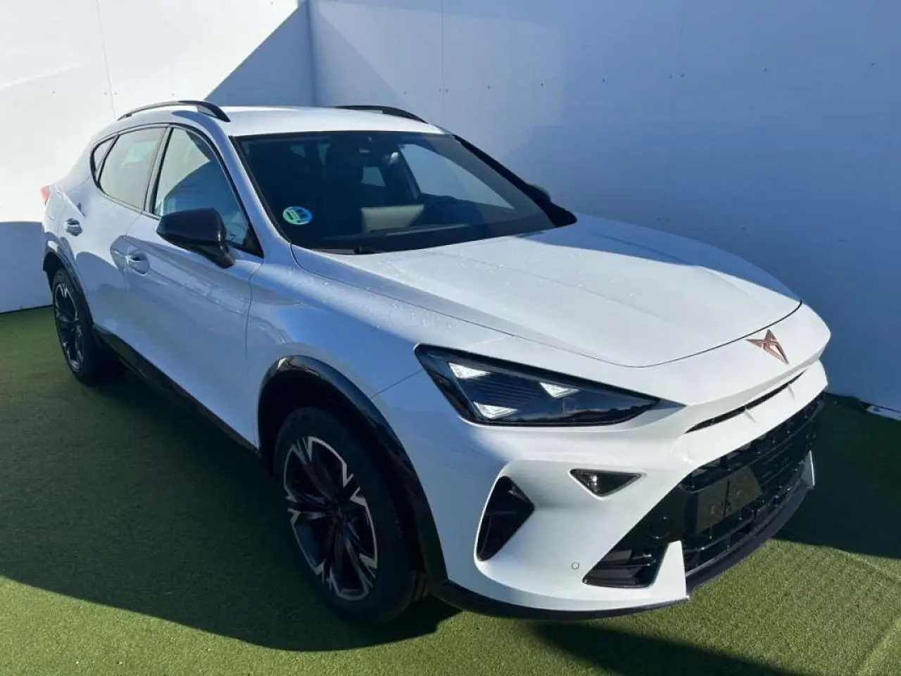 Vue 3/4 avant droite d'un CUPRA Formentor blanc 2025 avec phares LED et jantes noires distinctives.