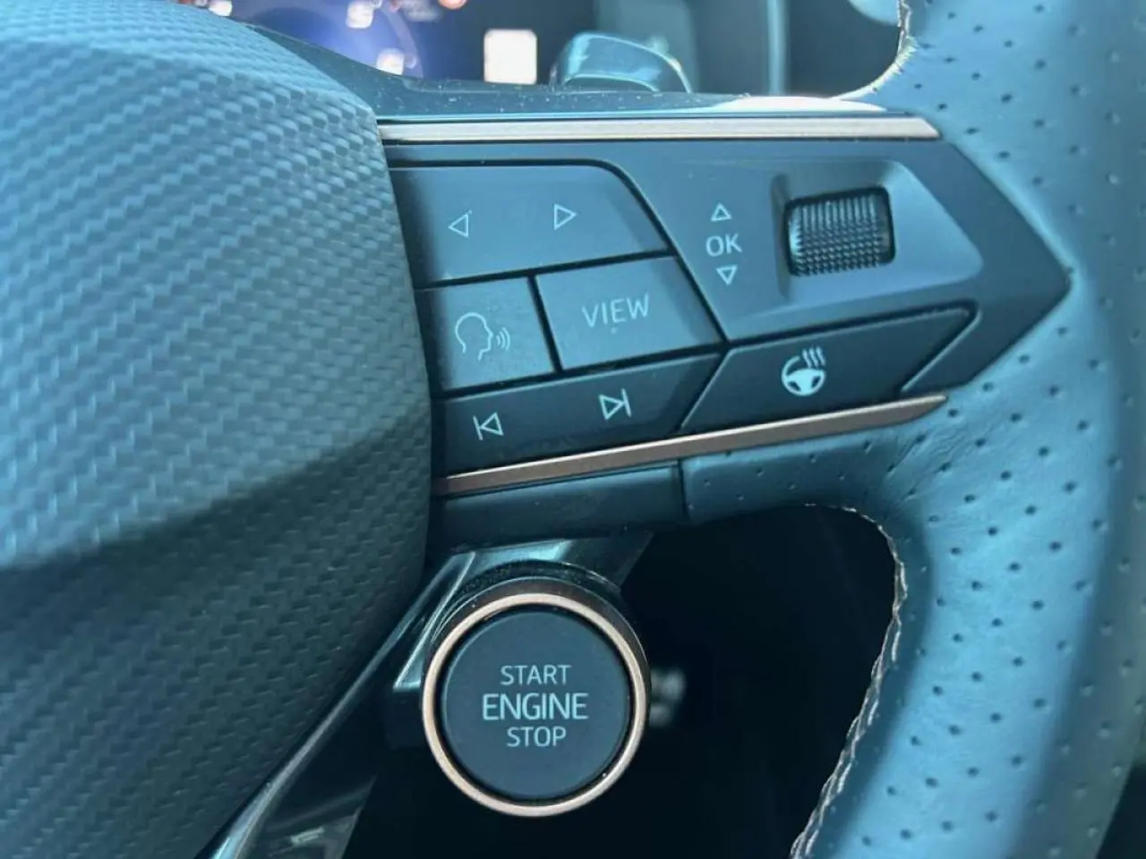 Gros plan sur le volant perforé noir du CUPRA Formentor blanc 2025, avec boutons multifonctions et bouton start/stop.