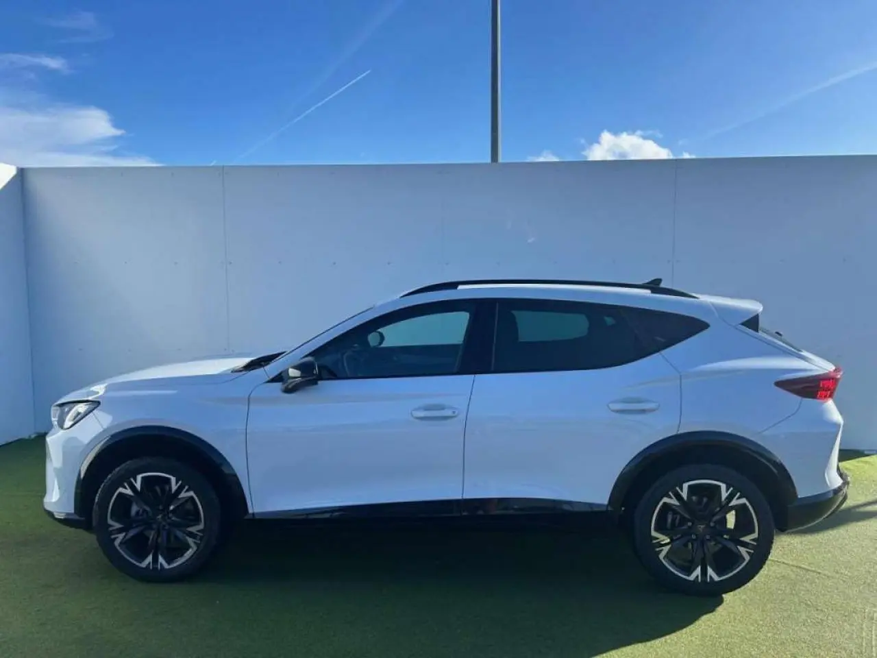 Vue de profil côté gauche du CUPRA Formentor blanc 2025 avec jantes noires et toit ouvrant.