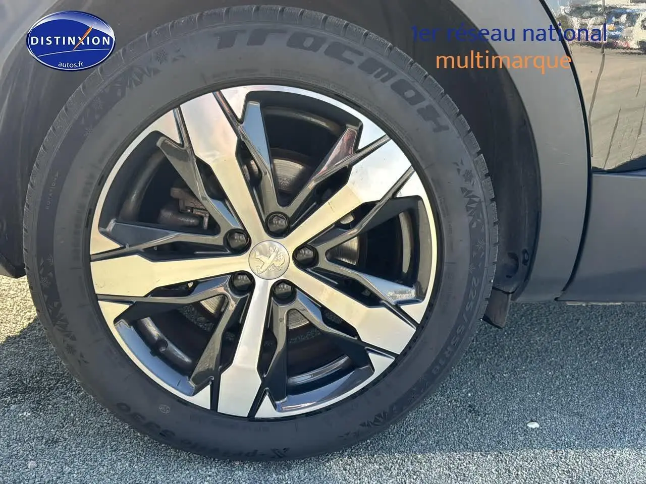 Gros plan sur la jante alu noire et argentée du côté gauche d'un Peugeot 3008 noir métal 2022.