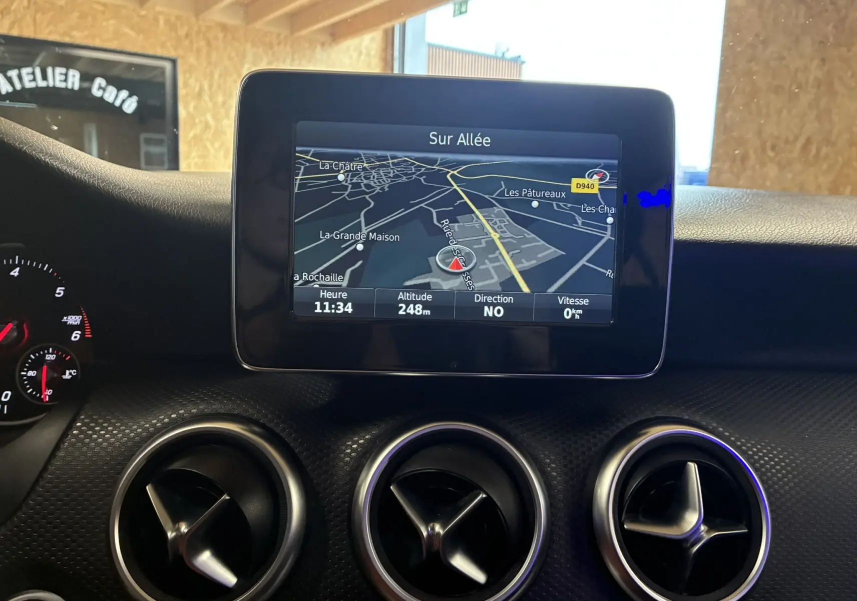 Vue intérieure du tableau de bord noir de la Mercedes Classe A 200D 2016 avec écran GPS et aérateurs ronds chromés.