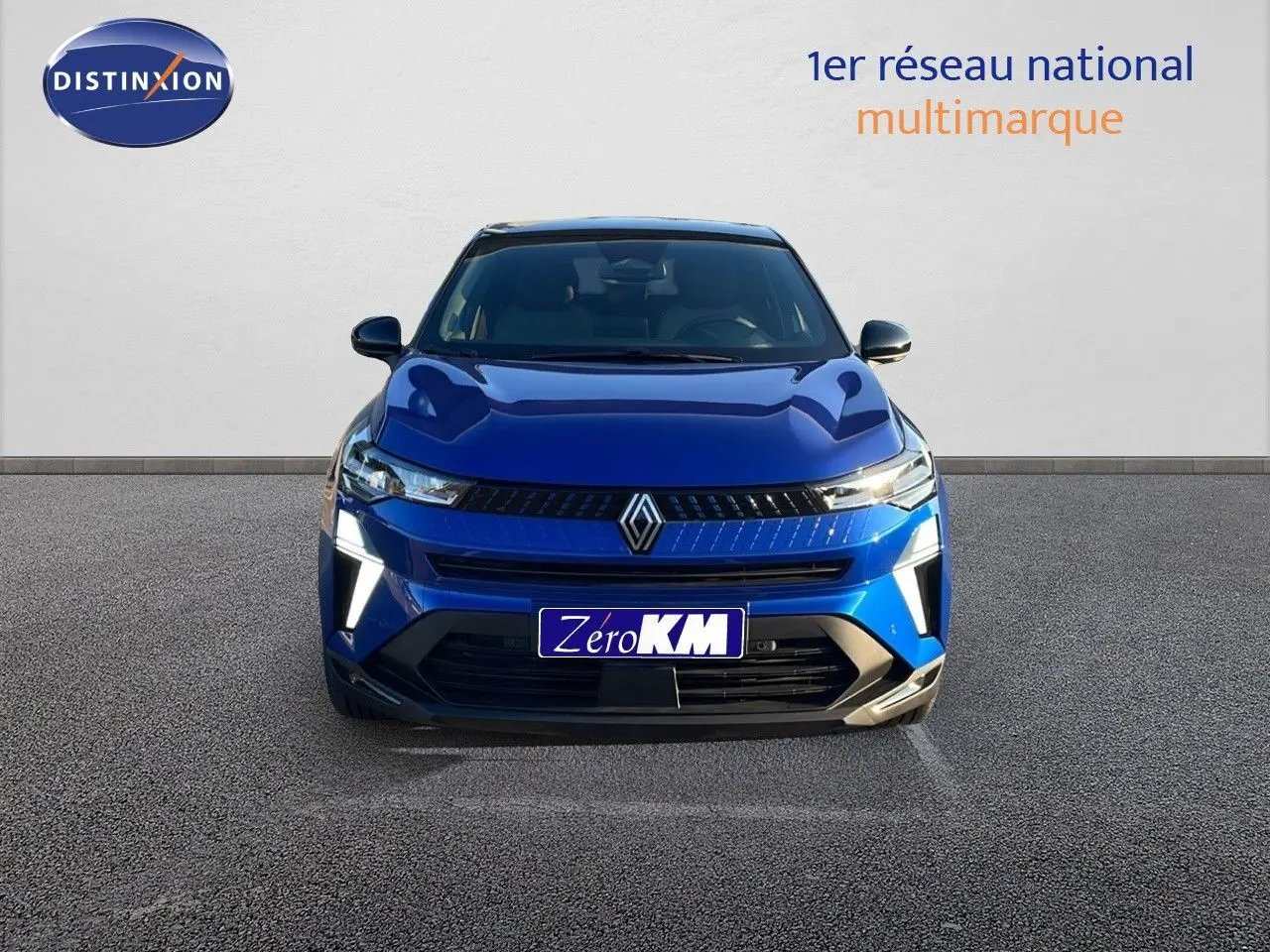 Vue avant du Renault Captur E-Tech hybride 2025 en bleu Iron Metal avec toit noir et feux LED allumés.