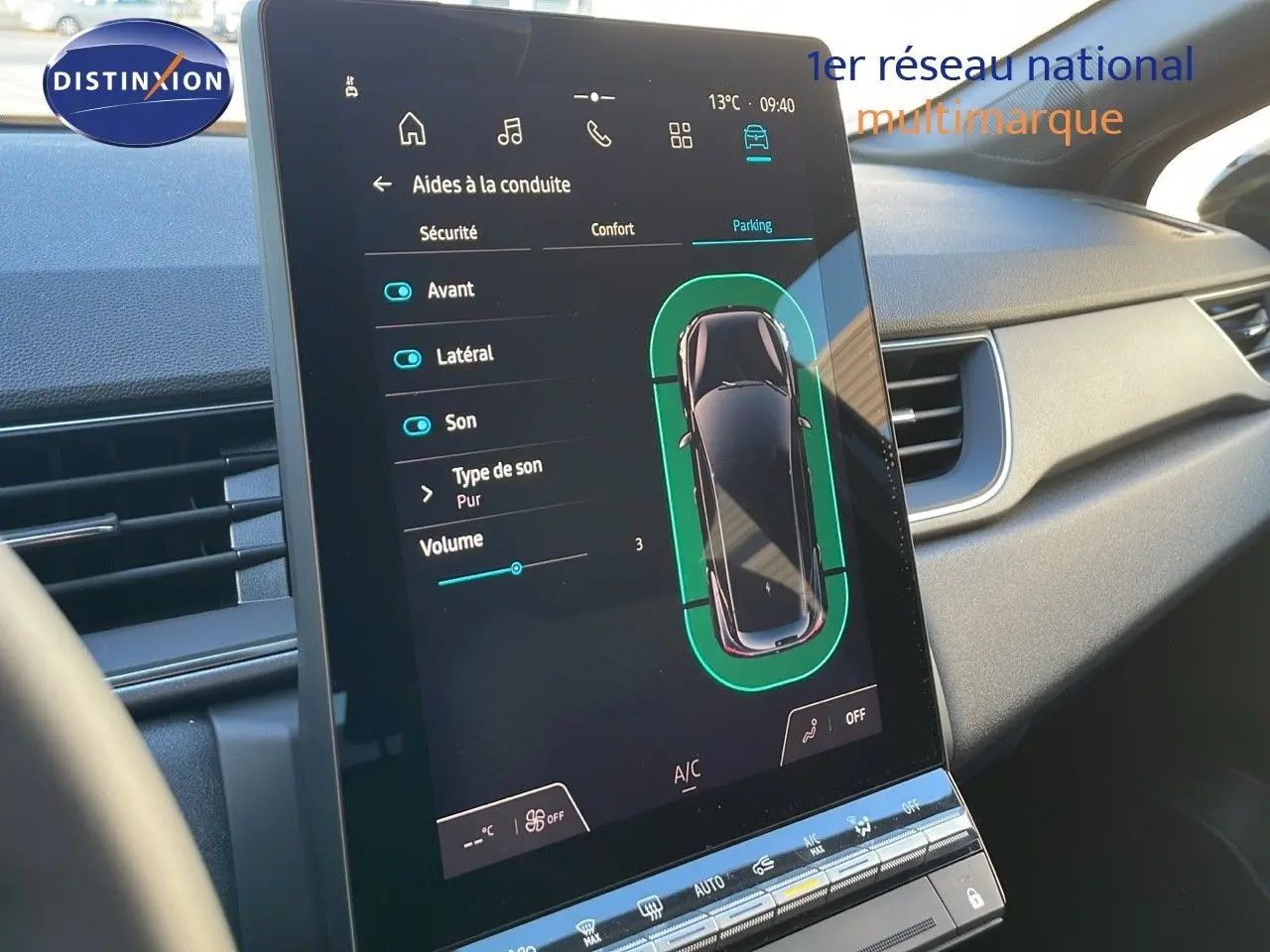 Écran tactile central affichant les aides à la conduite dans l'habitacle du Renault Captur bleu iron métal toit noir.