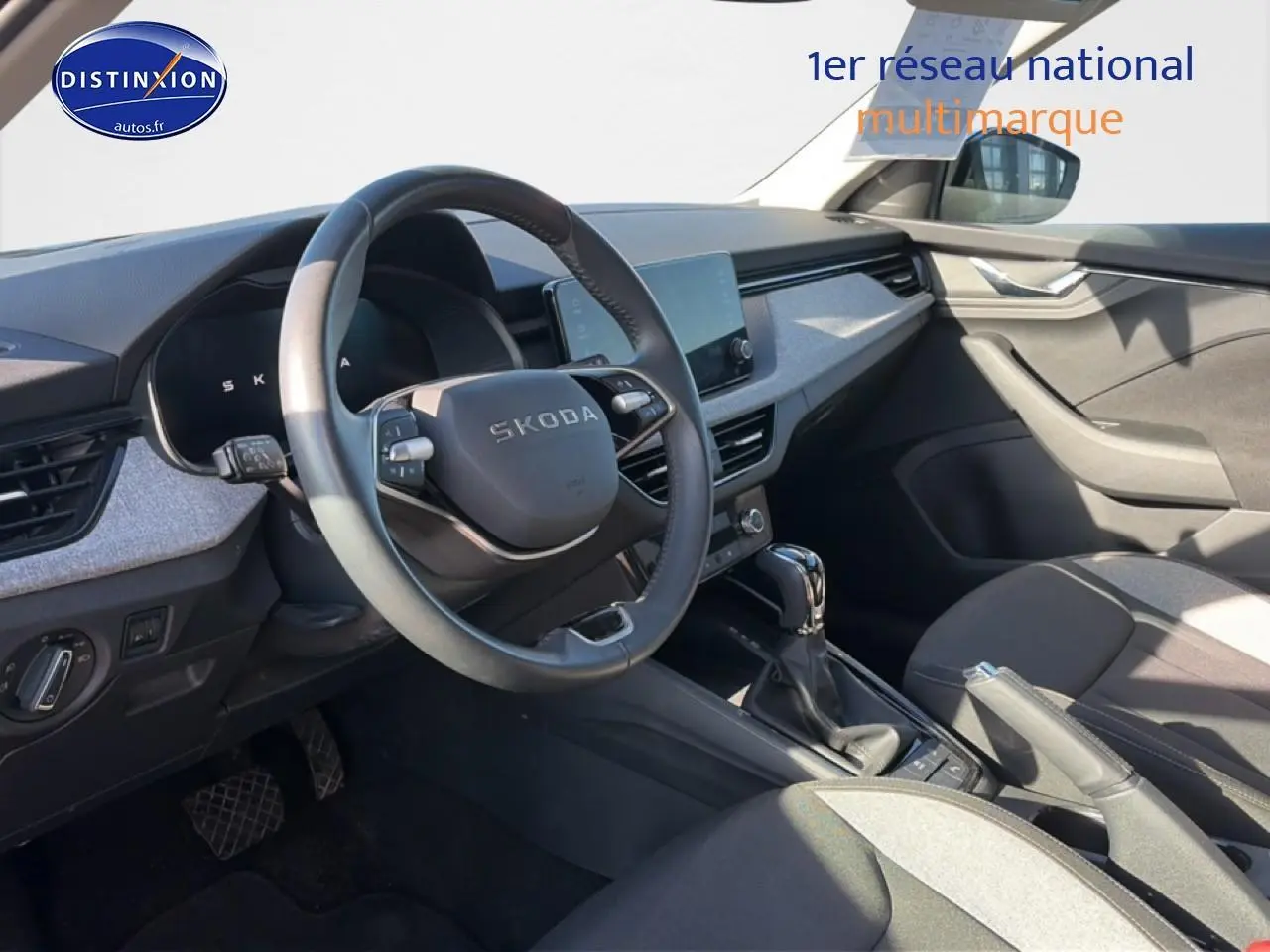 Intérieur avant droit du Skoda Kamiq noir 2025, volant cuir multifonction et écran tactile central visible.