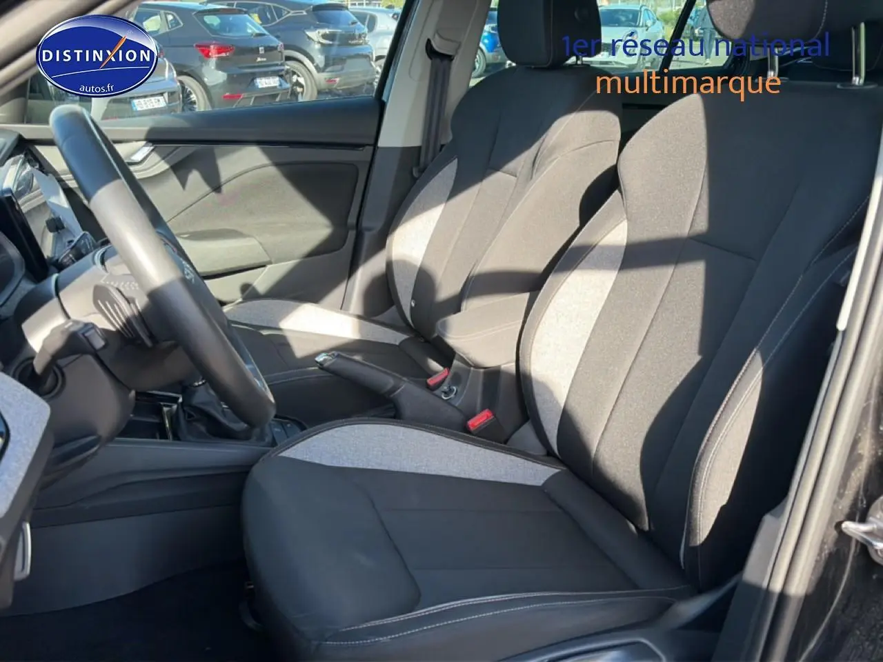 Vue intérieure côté conducteur du Skoda Kamiq noir 2025, mettant en valeur les sièges bicolores et le volant multifonction cuir.