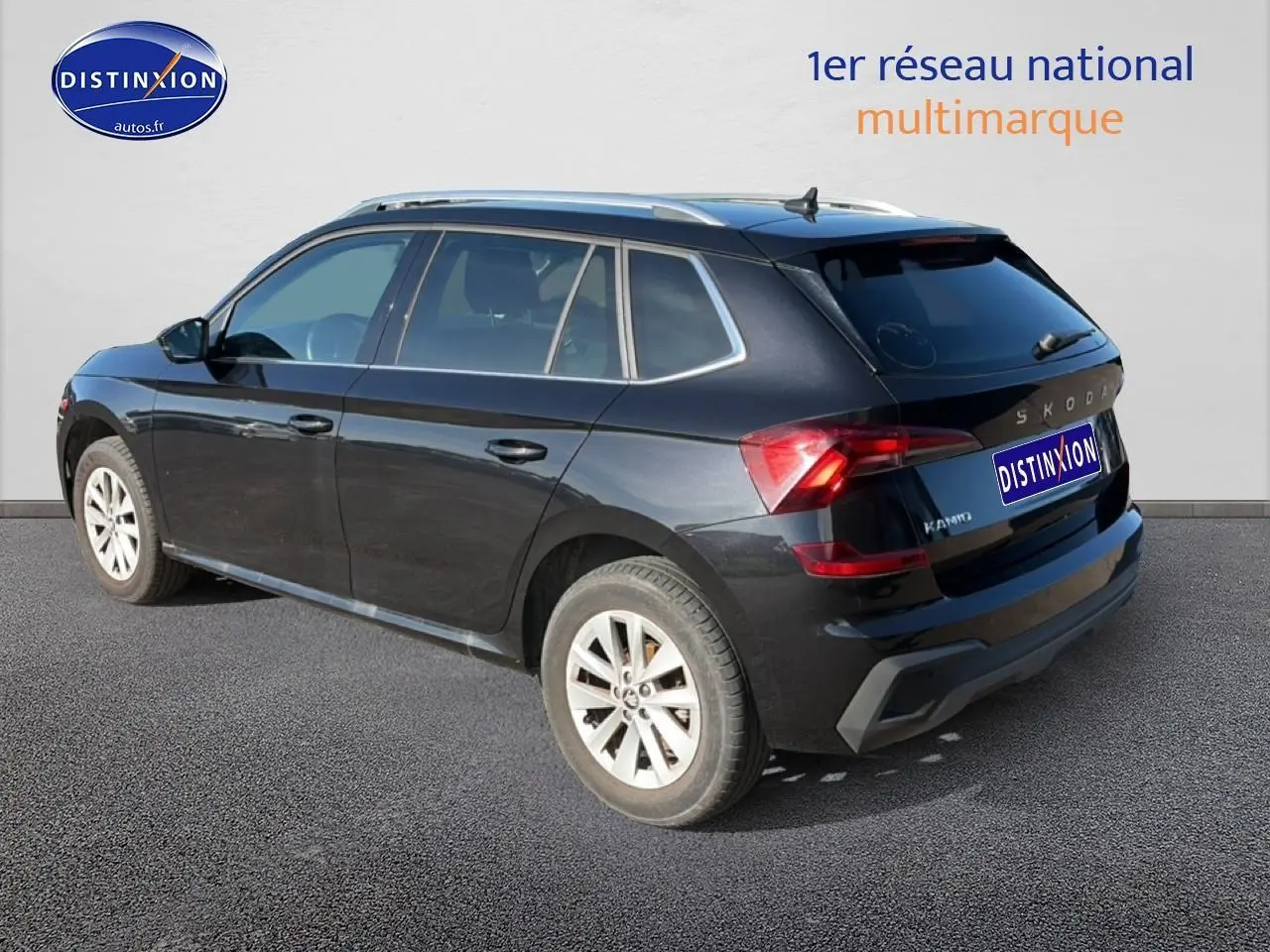 Vue 3/4 arrière droite d'un Skoda Kamiq noir 2025 avec jantes alu et barres de toit visibles.