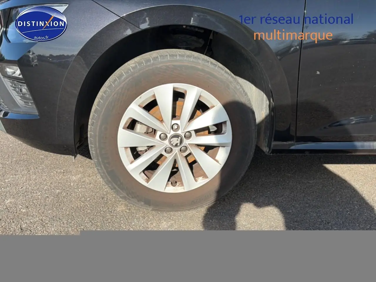 Gros plan sur la roue avant gauche et partie latérale noire d'une Skoda Kamiq 2025 avec jante alu et calandre chromée.