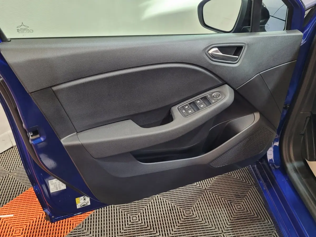 Vue rapprochée de la porte avant gauche bleu Renault Clio 2025, avec commandes électriques et haut-parleur intégré.