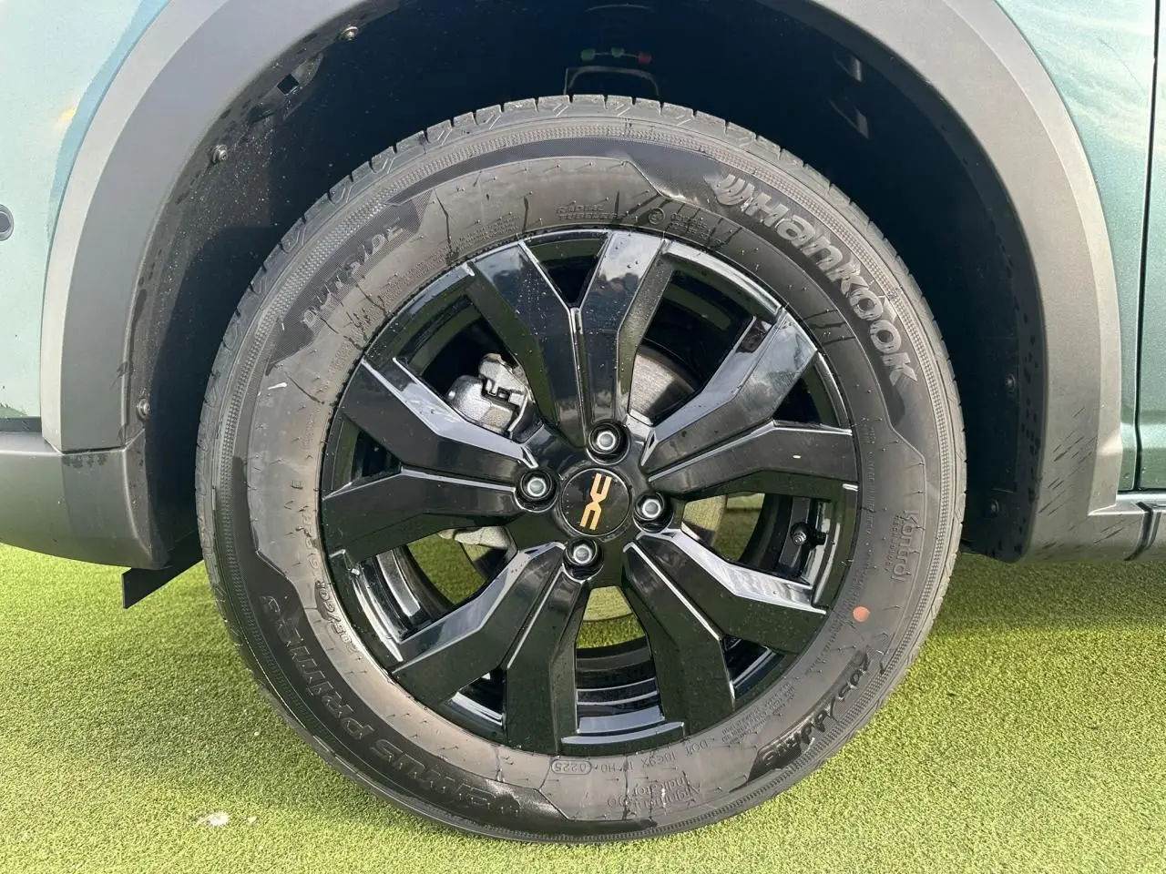 Gros plan sur la roue arrière droite noire brillante de la Dacia Sandero III Stepway Vert Cèdre avec jante aluminium 16 pouces.