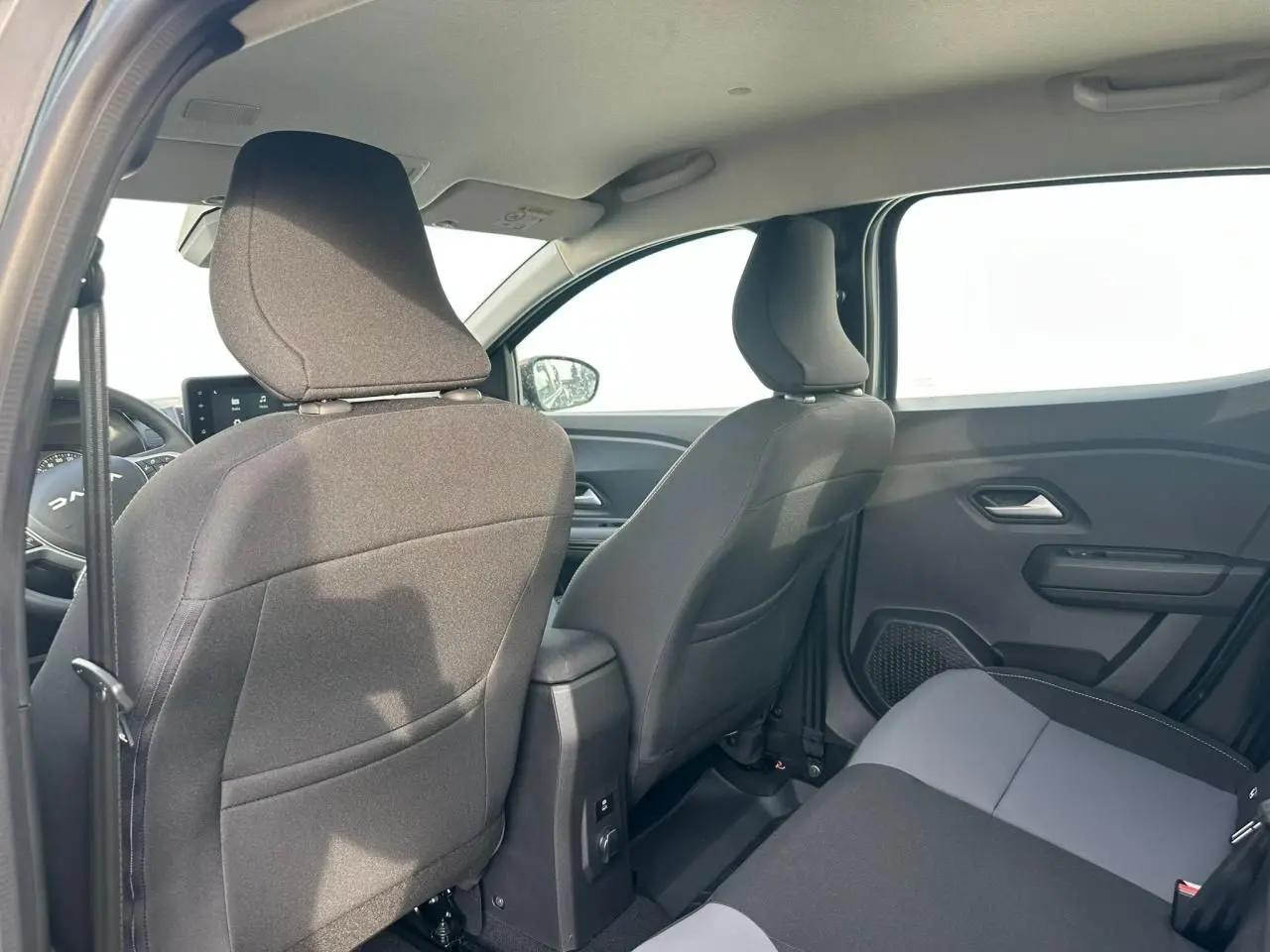 Vue intérieure arrière côté droit de la Dacia Sandero III Stepway 2025 avec sièges tissu gris et noir.