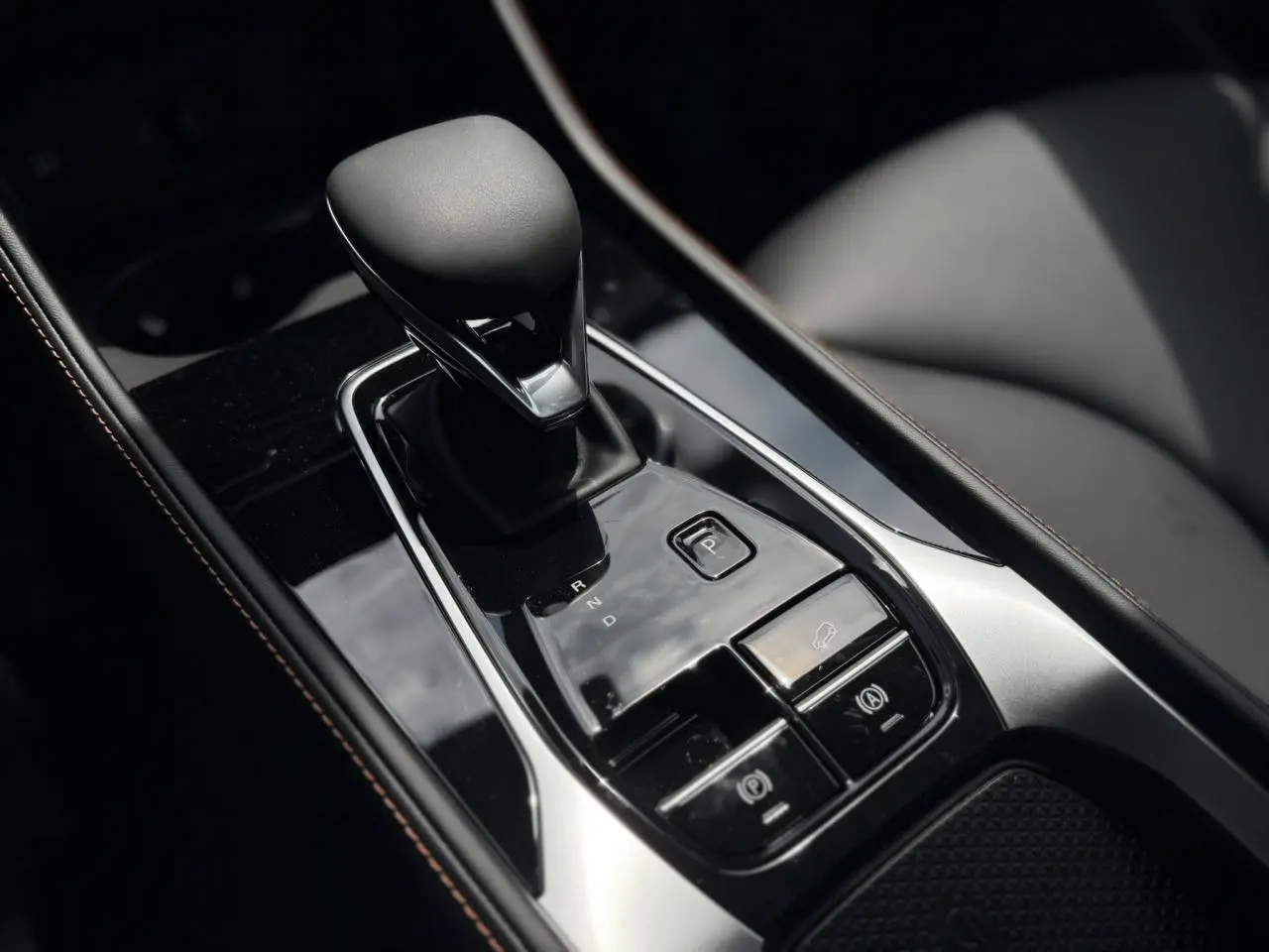 Gros plan sur la console centrale noire du MG Motor EHS 1.5 Hybrid+ 224 Luxury avec levier de vitesse automatique.