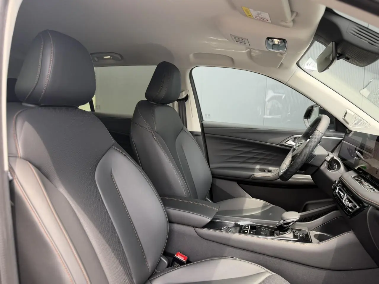 Intérieur noir du MG Motor EHS 1.5 Hybrid+ 224 Luxury, vue côté droit sur sièges avant et console centrale.