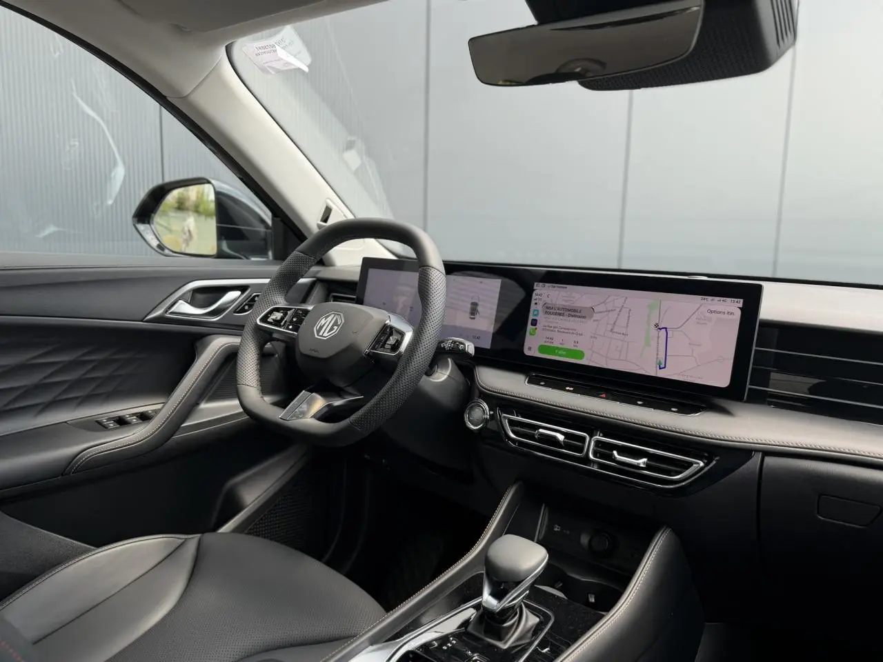 Intérieur noir du MG Motor EHS 1.5 Hybrid+ 224 Luxury vu côté conducteur, avec écran tactile large et volant multifonction.