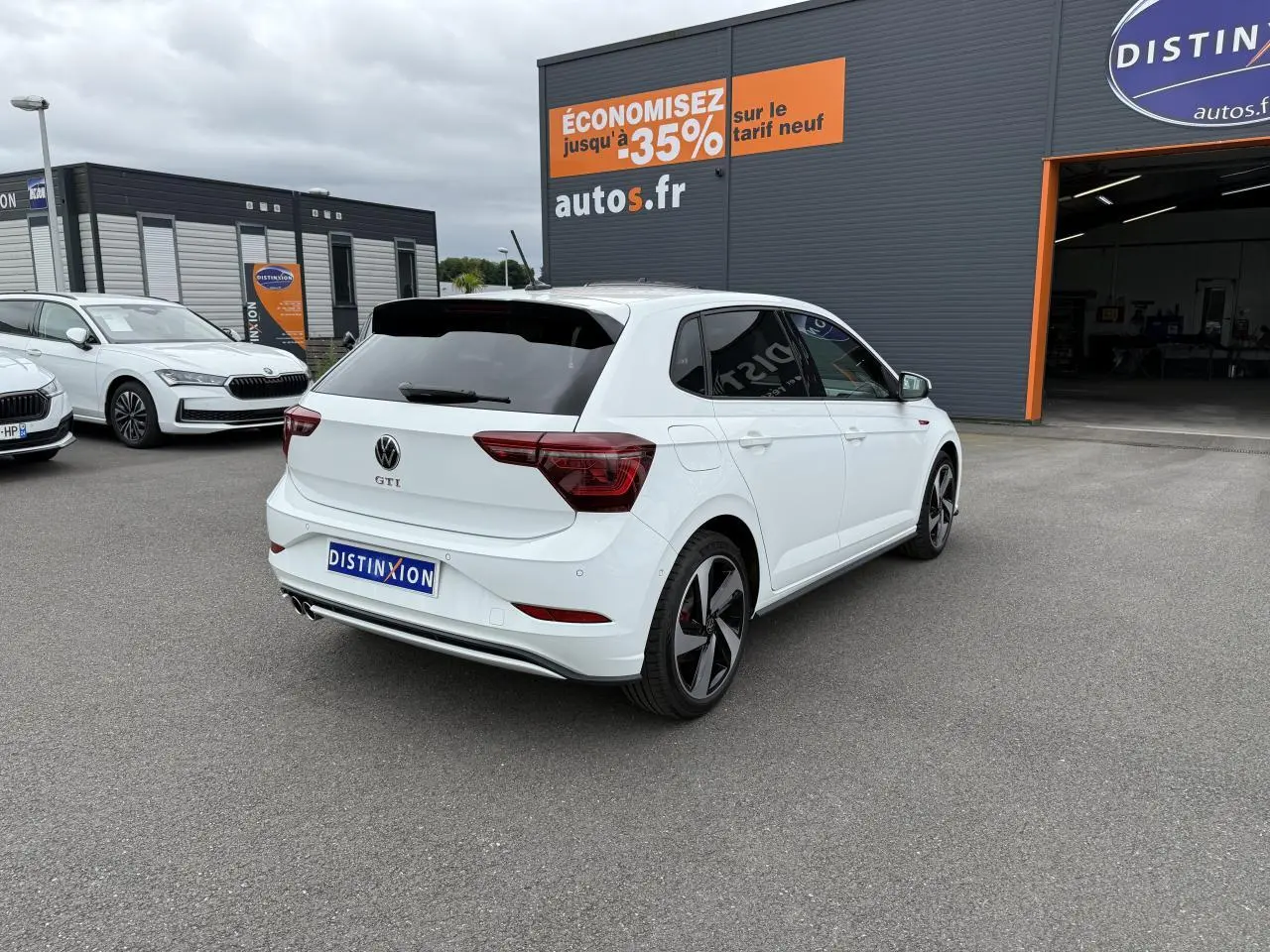 Volkswagen Polo GTI blanche vue 3/4 arrière droit, avec jantes sport et vitres arrière surteintées.