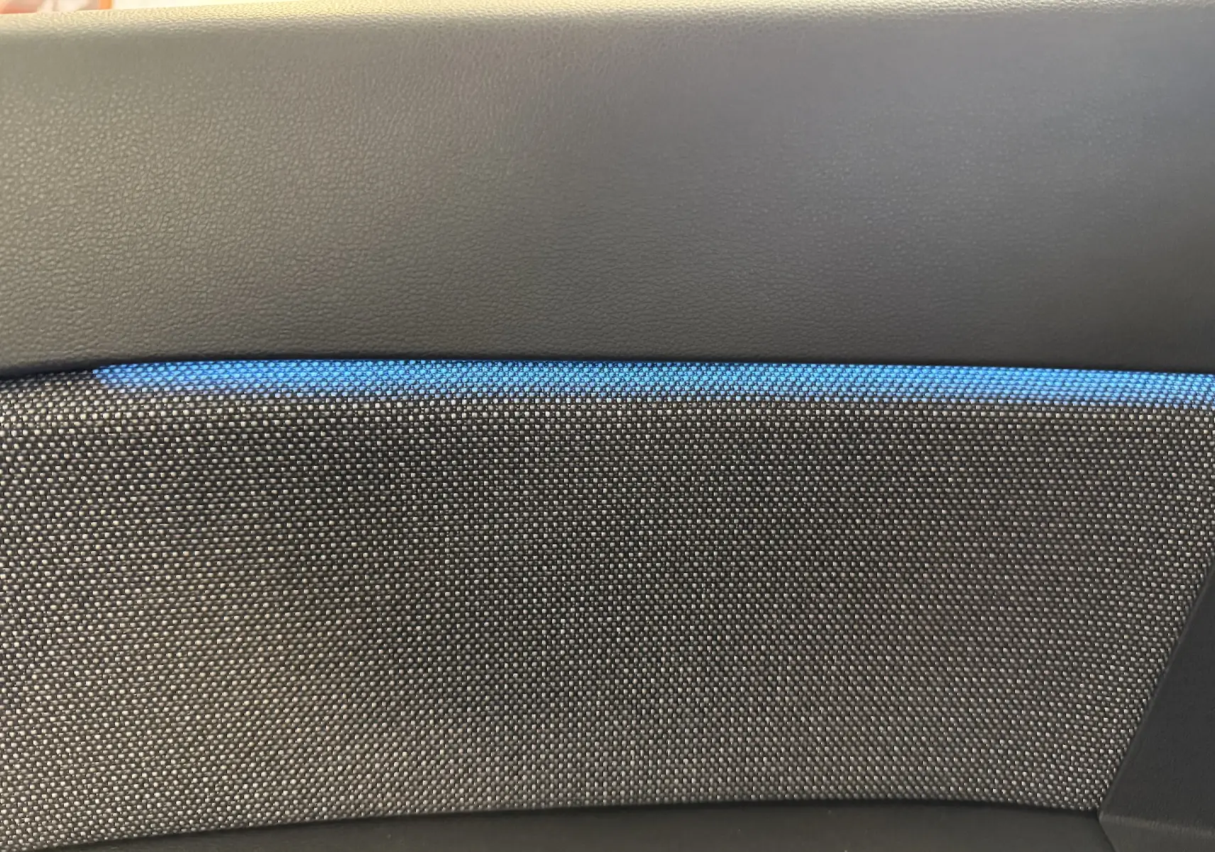 Détail de la garniture intérieure grise avec bande lumineuse bleue du Renault Captur 1.6 E-TECH Full Hybrid 2025.
