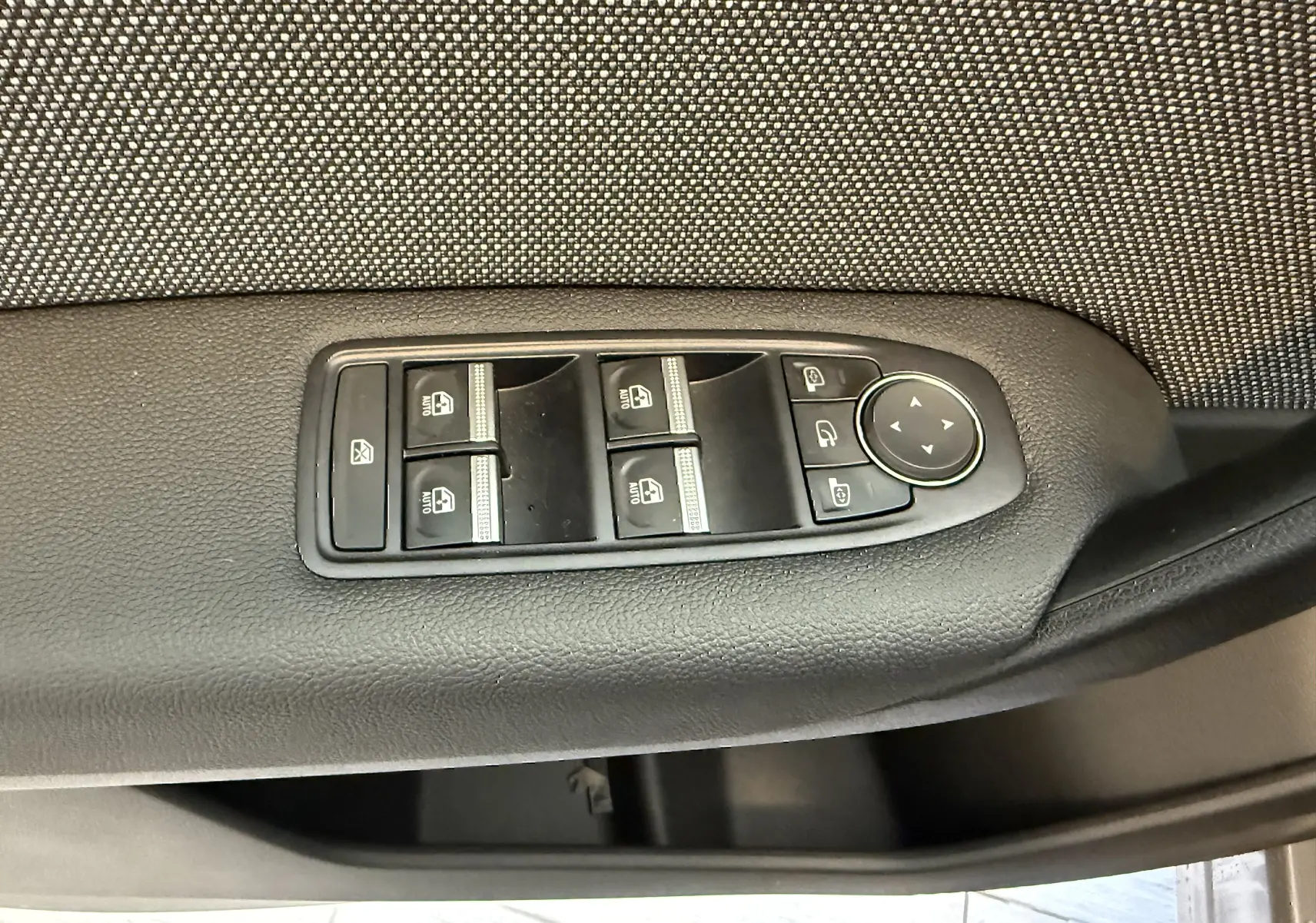 Panneau de commandes des vitres électriques et rétroviseurs sur la portière côté gauche d’un Renault Captur gris Cassiopée 2025.