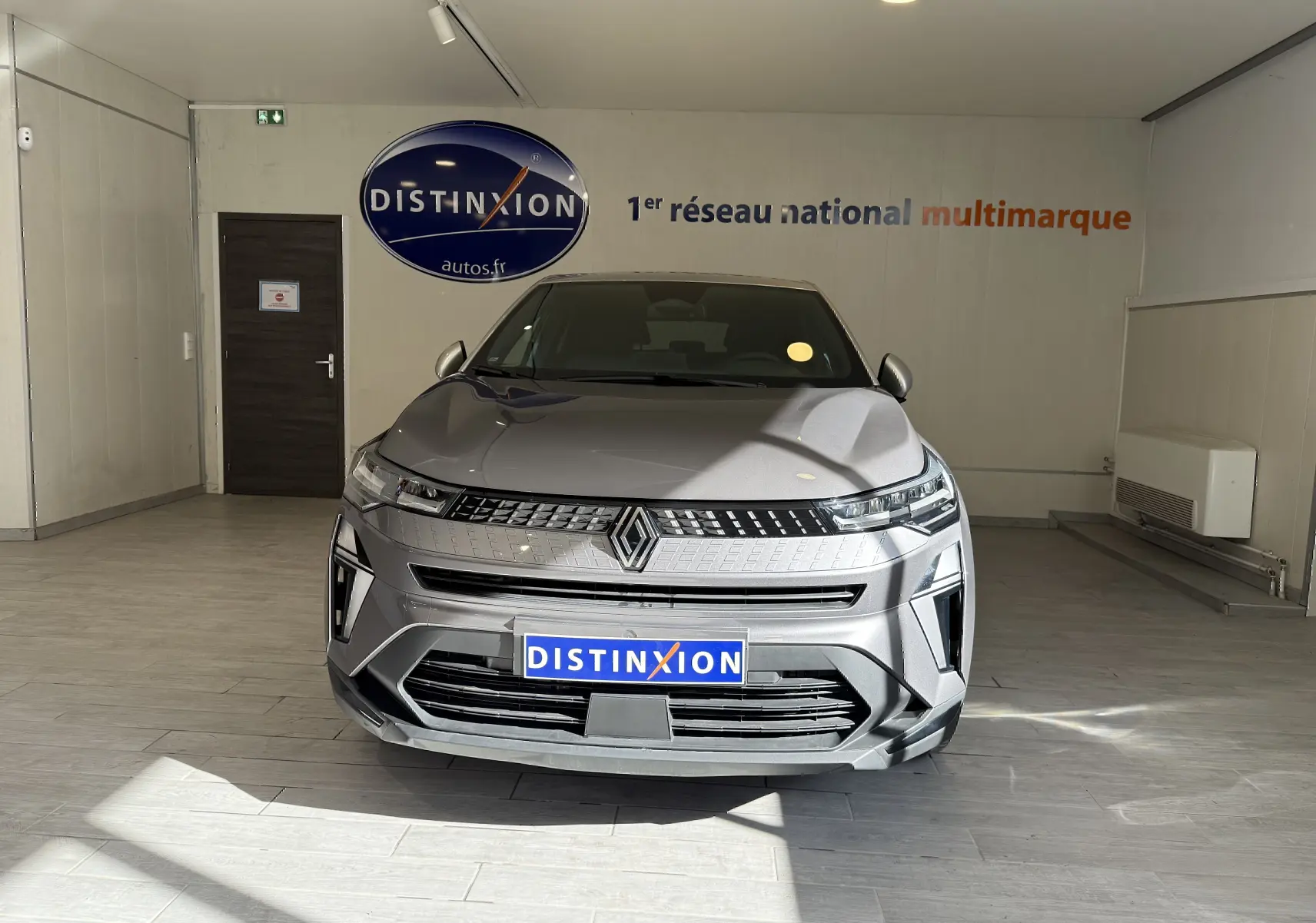 Vue frontale du Renault Captur 1.6 E-TECH gris Cassiopée métal avec calandre moderne et logo central lumineux.
