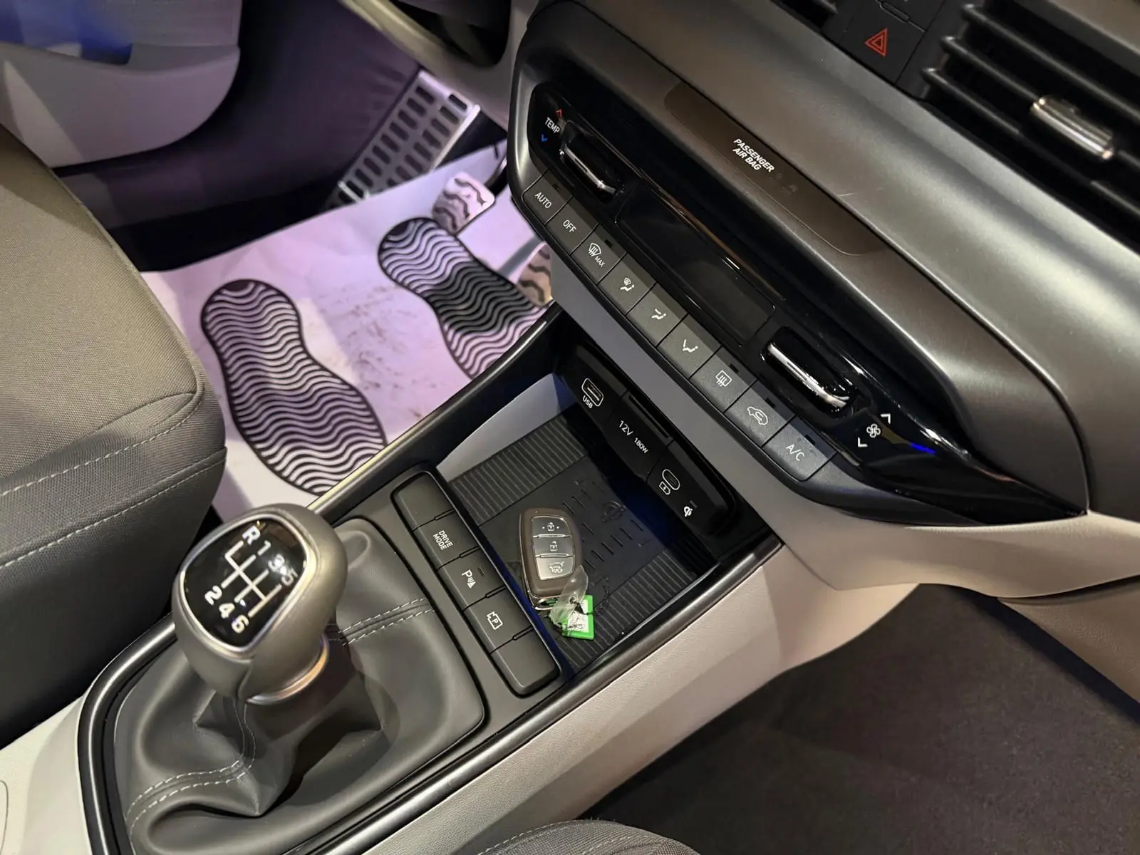 Gros plan sur la console centrale intérieure grise et noire du Hyundai Bayon 2025 avec levier de vitesse manuel et clés posées.