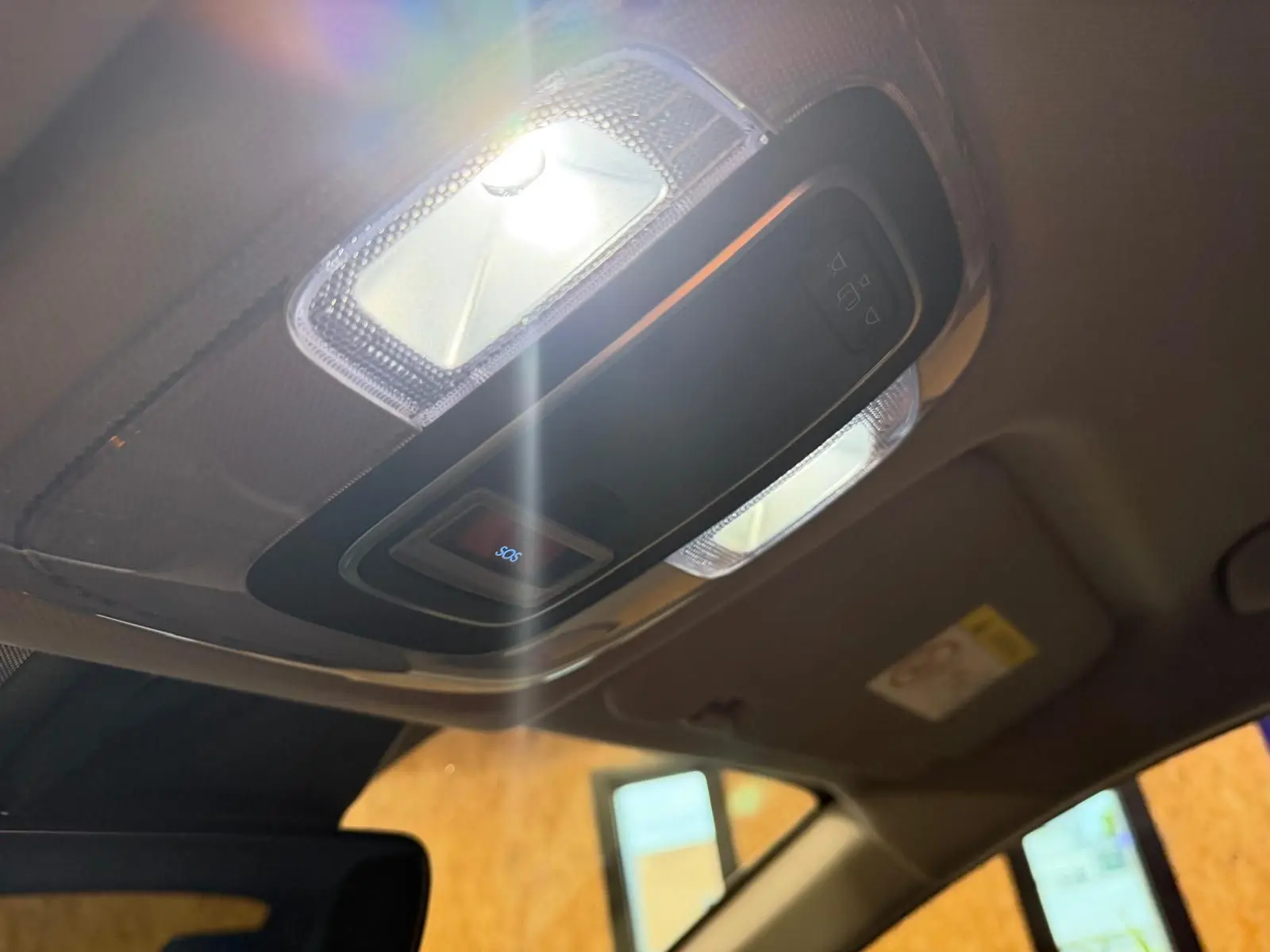Plafonnier intérieur allumé avec bouton SOS visible dans l'habitacle du Hyundai Bayon rouge 2025.