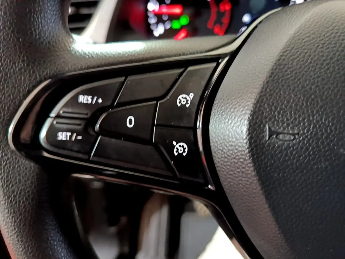 Gros plan sur les commandes de régulateur de vitesse au volant noir du Renault Kangoo Equilibre blanc 2022.