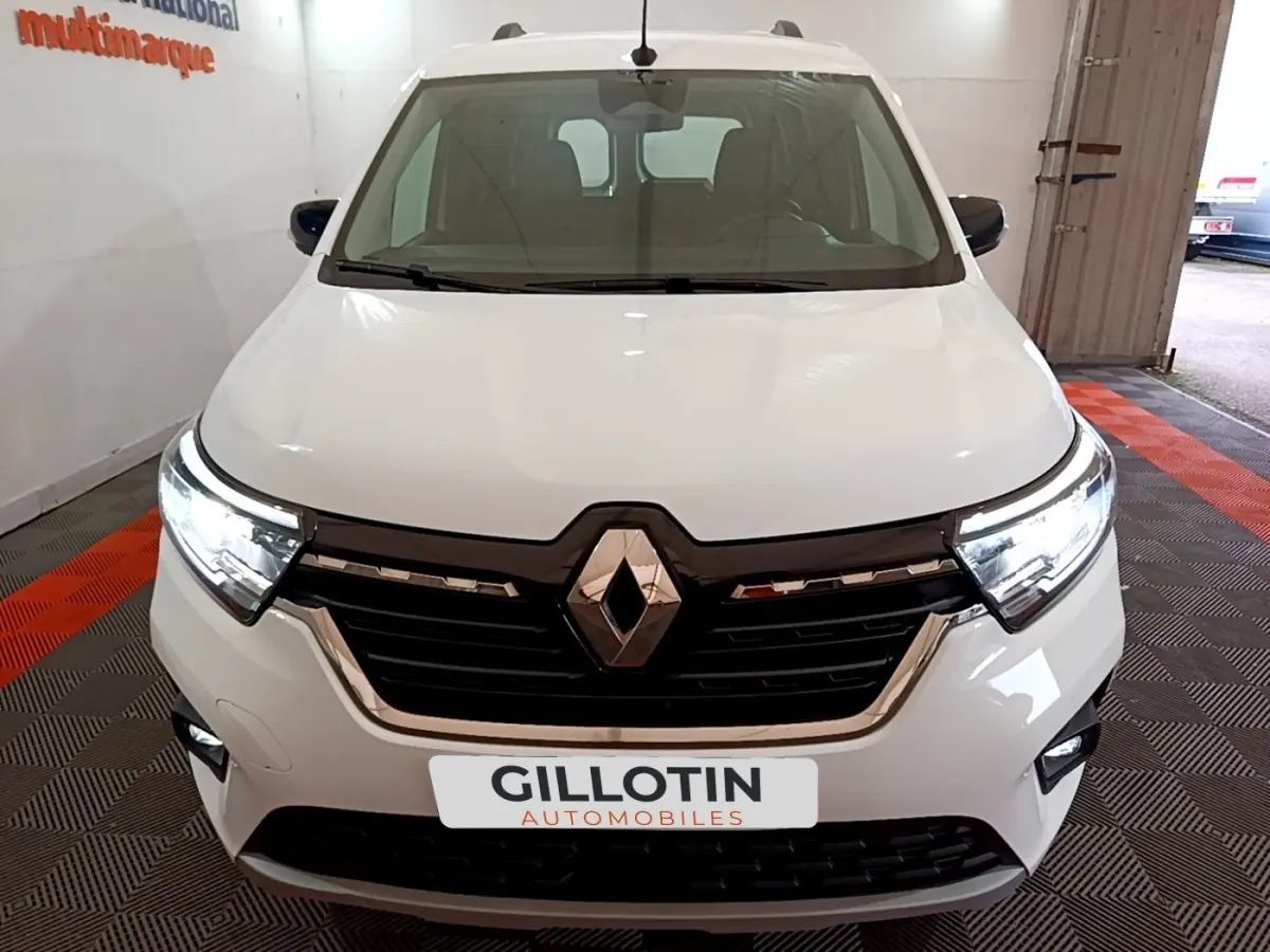 Vue avant d'un Renault Kangoo blanc 2022 avec phares LED allumés et calandre noire brillante.