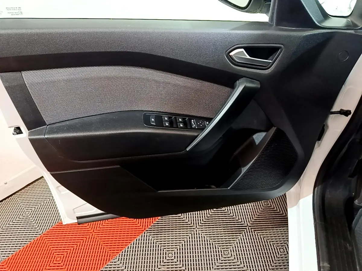 Vue rapprochée de la porte avant gauche blanche du Renault Kangoo Equilibre 2022 avec commandes de vitres et poignée noire.