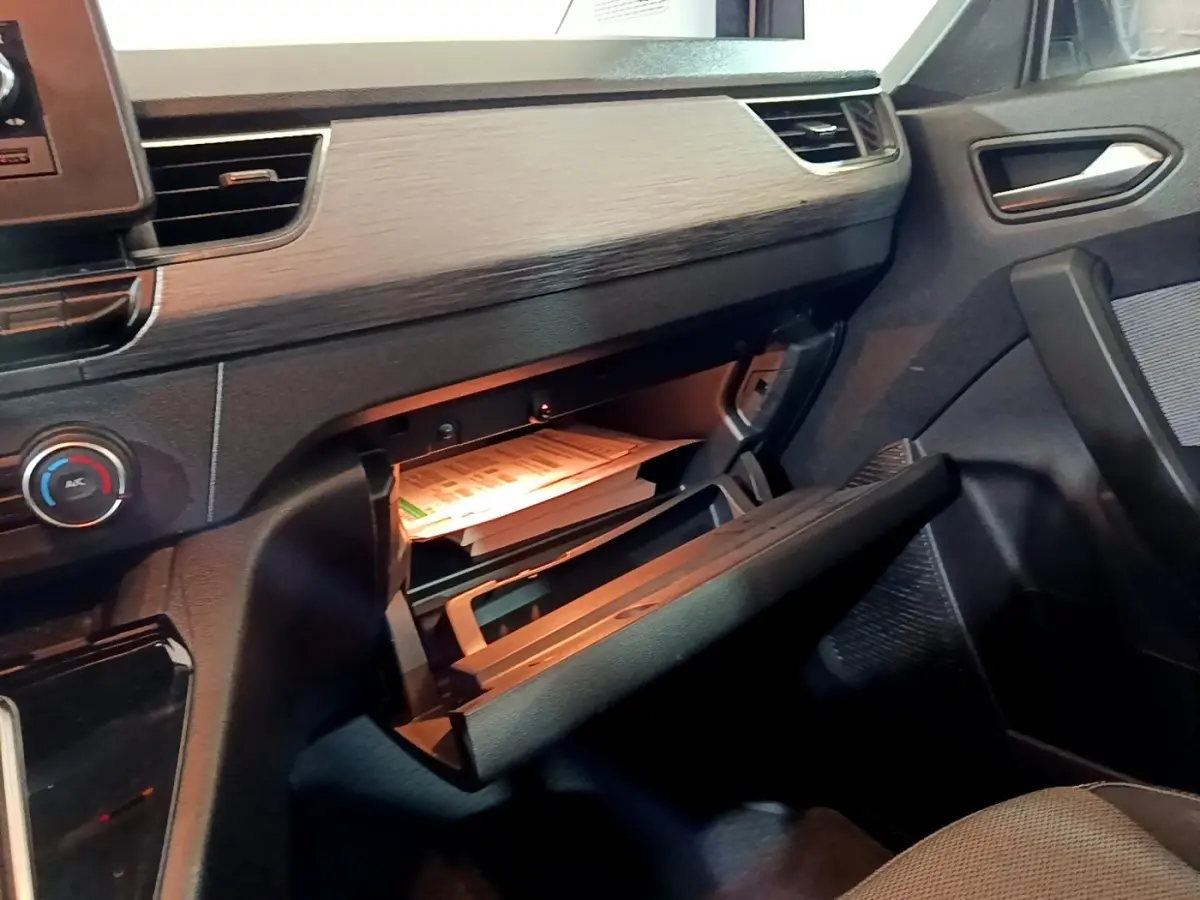 Intérieur du Renault Kangoo Equilibre 2022, vue côté passager sur la boîte à gants ouverte avec documents visibles.