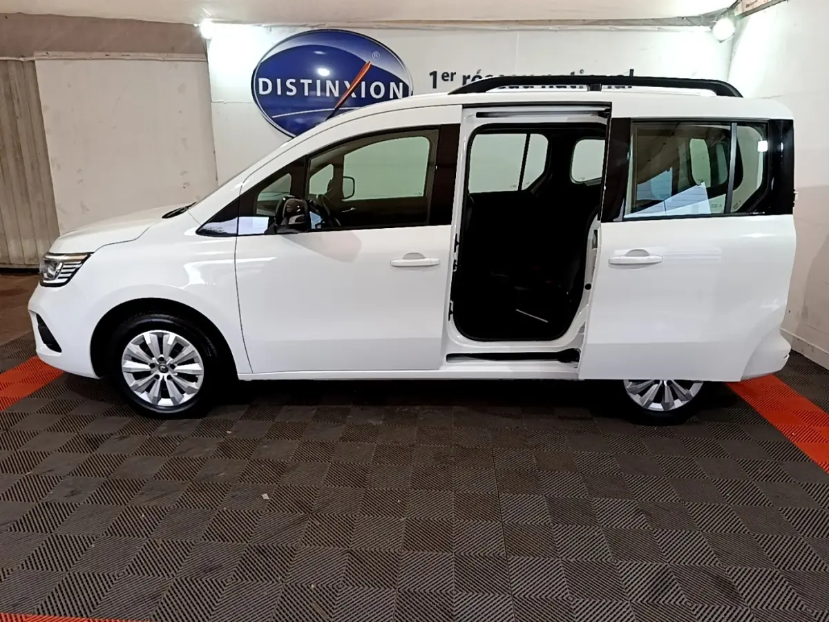 Profil droit d’un Renault Kangoo blanc 2022 avec porte coulissante arrière ouverte, intérieur sombre visible.