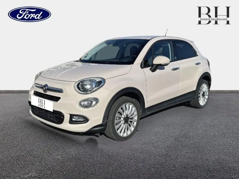Vue 3/4 avant droite d'une FIAT 500X argentée avec jantes alliage et détails noirs sur les bas de caisse.