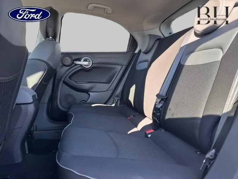 Vue intérieure arrière côté droit d'une Fiat 500X argentée, montrant la banquette tissu bi-color noir et gris.
