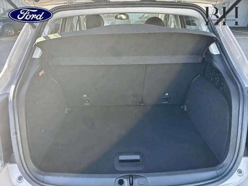 Vue arrière du coffre ouvert d'une FIAT 500X argentée de 2015, montrant l'espace de chargement vide et la tablette cache-bagages.