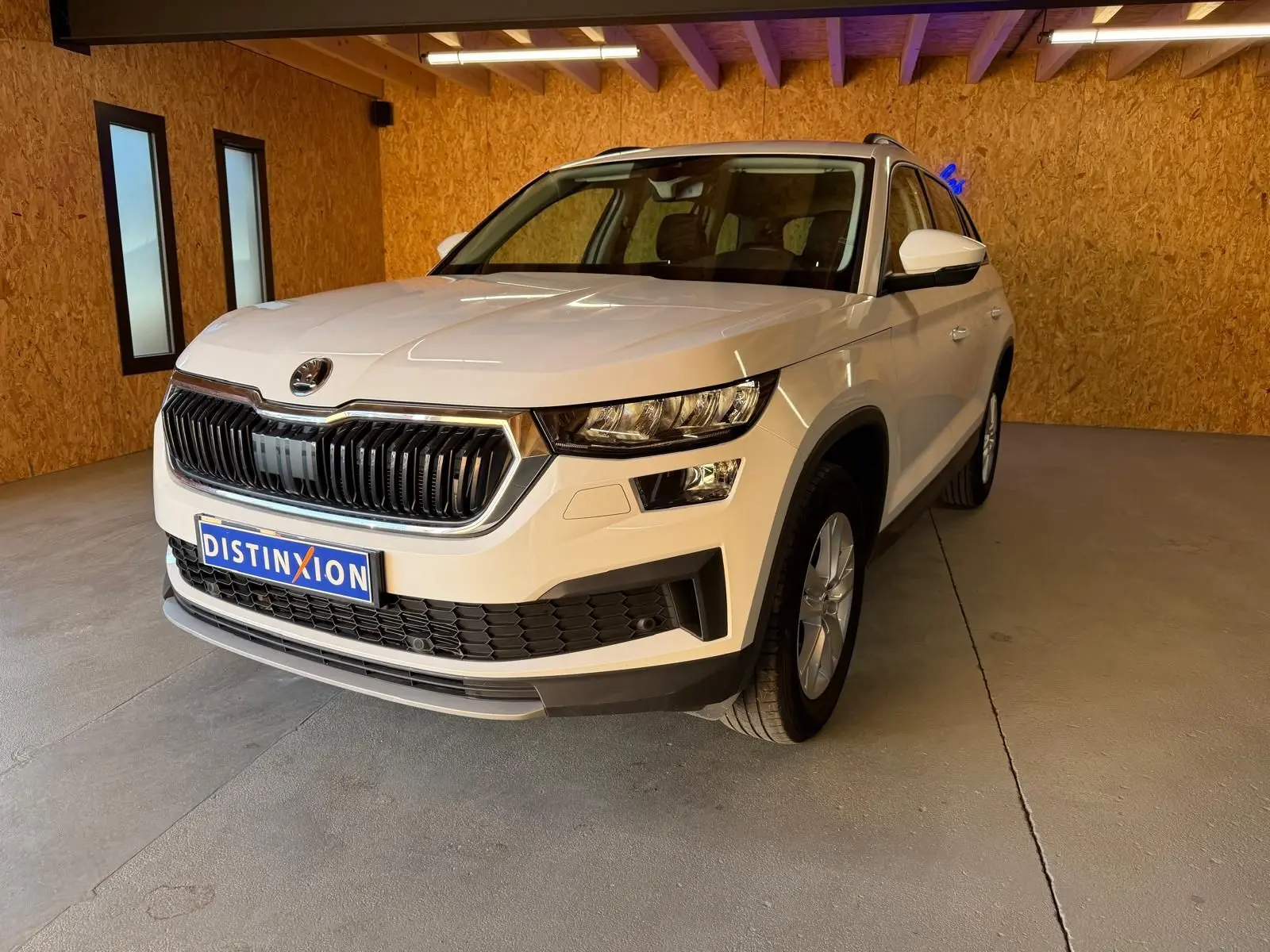 Vue 3/4 avant droite d'un Skoda Kodiaq blanc 2023 avec calandre noire et jantes alliage visibles.