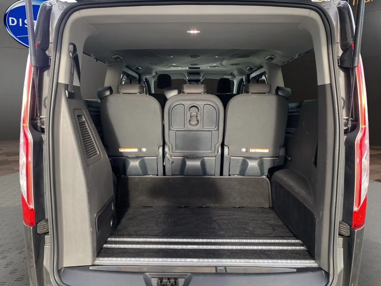 Vue arrière du Ford Tourneo Custom gris magnetic 2020 avec portes ouvertes et espace de chargement visible.
