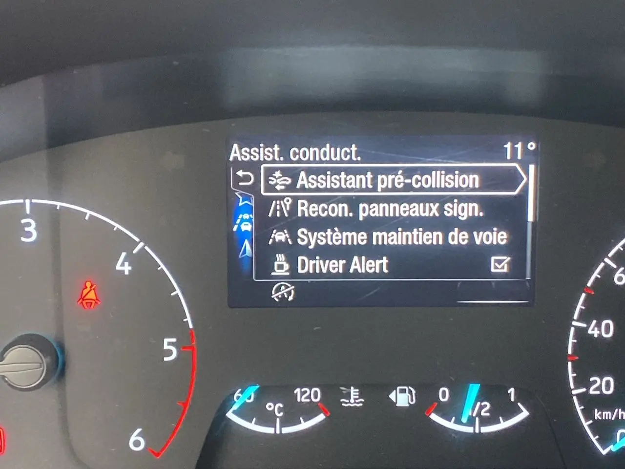 Tableau de bord du Ford Tourneo Custom gris, affichant les aides à la conduite sur l'écran central.