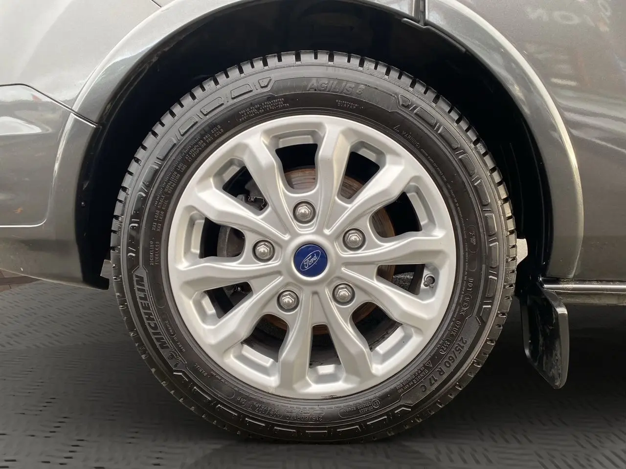 Gros plan sur la roue avant gauche du Ford Tourneo Custom gris magnetic, mettant en valeur la jante alliage et le pneu Michelin.