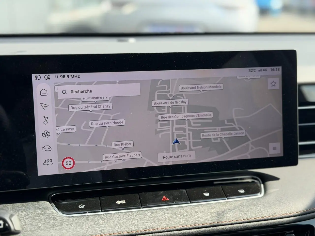 Vue rapprochée de l'écran tactile 12,3 pouces du MG Motor EHS gris, affichant la navigation connectée en extérieur.