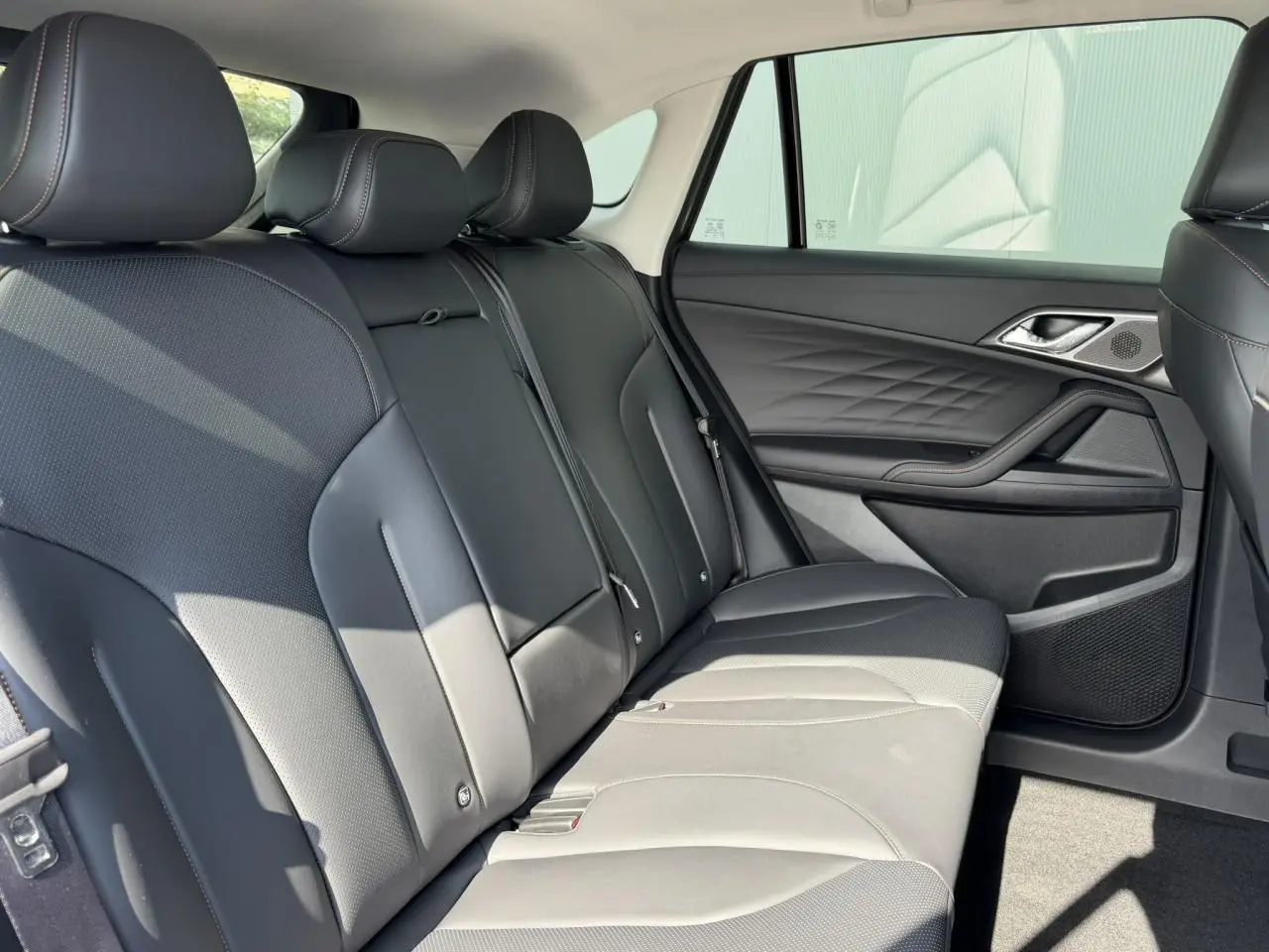Vue latérale droite de la banquette arrière en simili cuir noir avec surpiqûres contrastées du MG Motor EHS 1.5 Hybrid+ 224 Luxury.