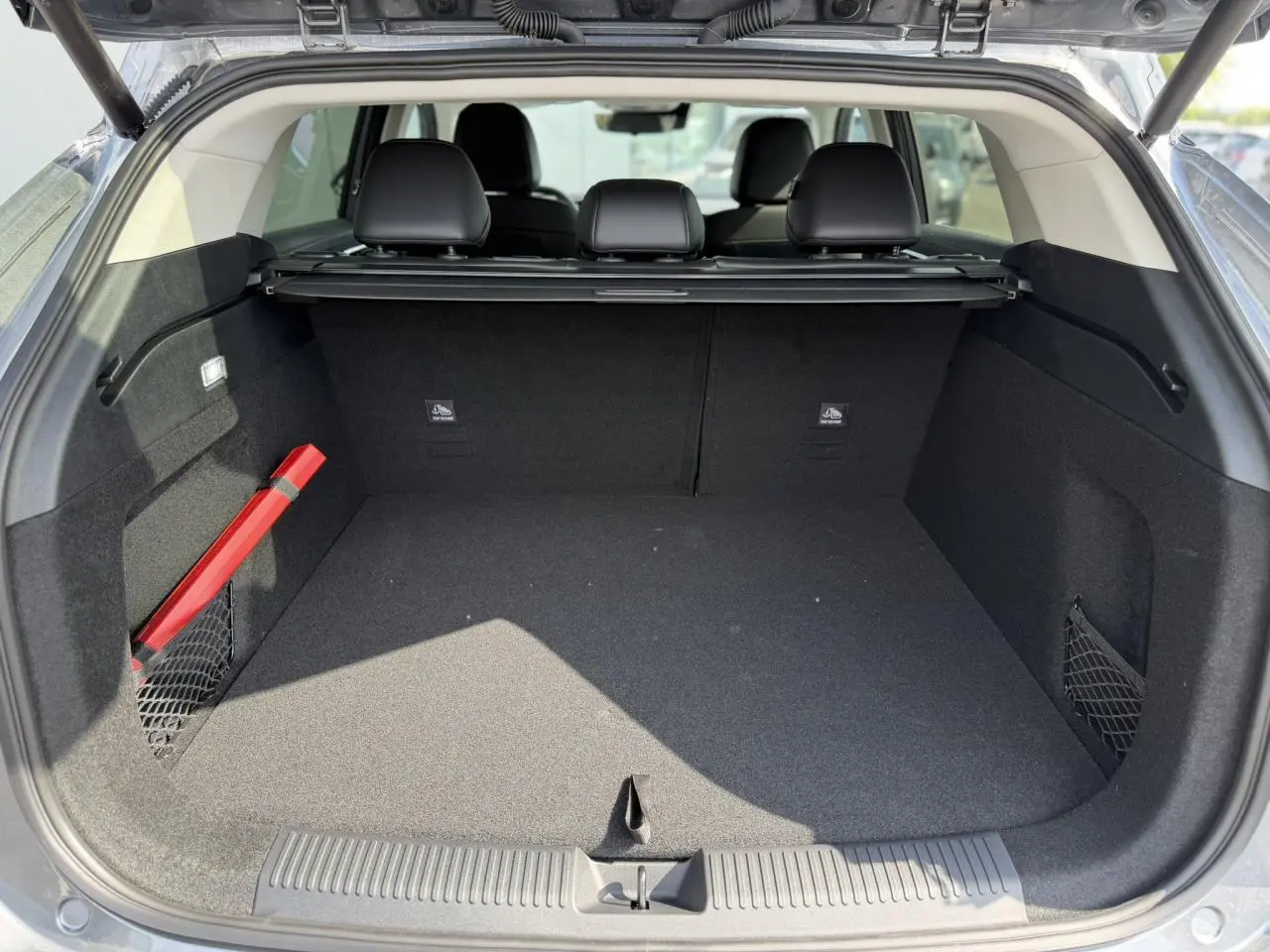 Coffre ouvert vu de l'arrière d'un MG MOTOR EHS gris, montrant un espace de chargement propre et bien agencé.