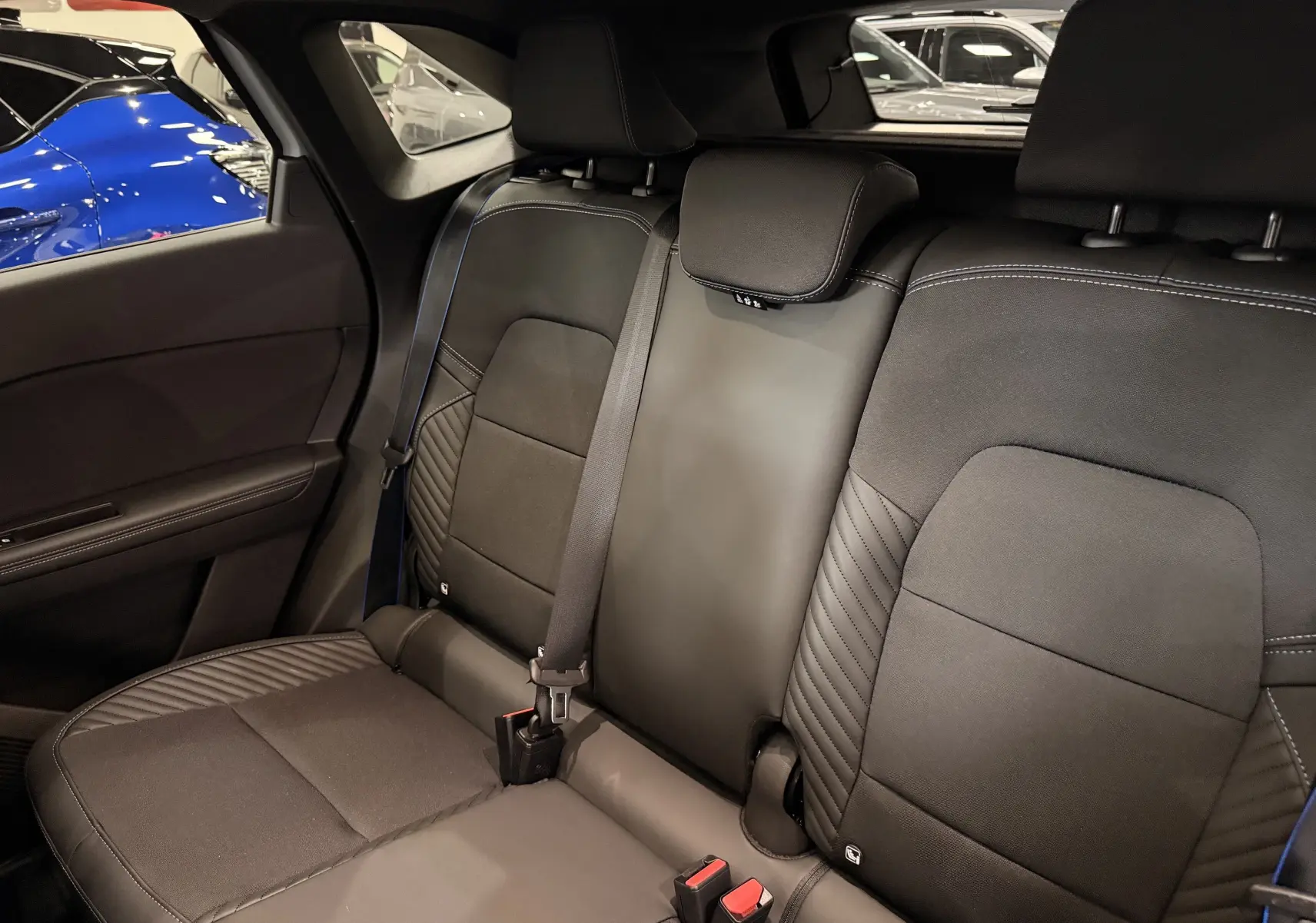 Vue intérieure des sièges arrière en tissu noir avec surpiqûres bleues du Renault Symbioz E-Tech full hybrid 2026.