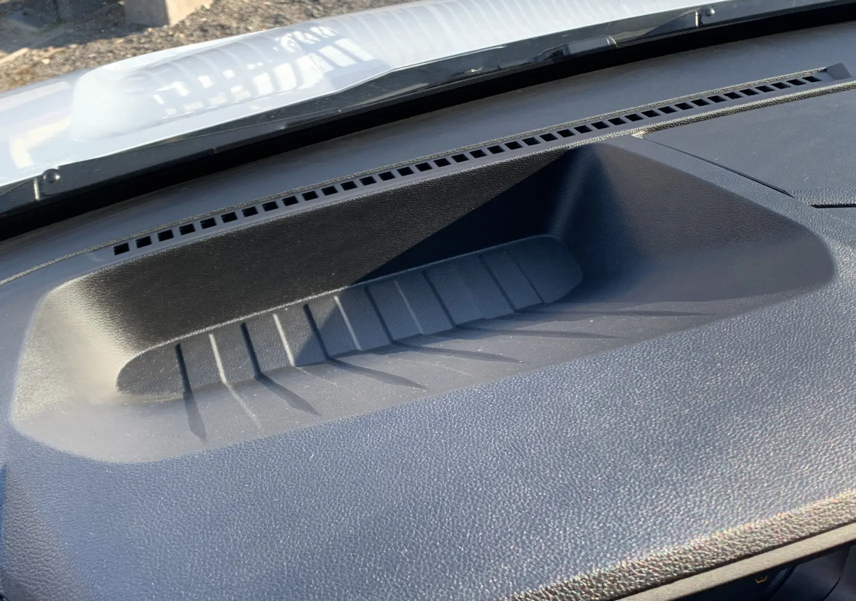 Détail du tableau de bord noir du Renault Master 2025 blanc, avec rangement intégré sous le pare-brise.