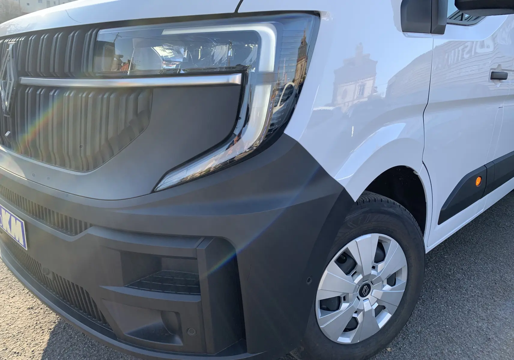 Vue 3/4 avant droit d'un Renault Master blanc mine avec pare-chocs noir mat et jante argentée.