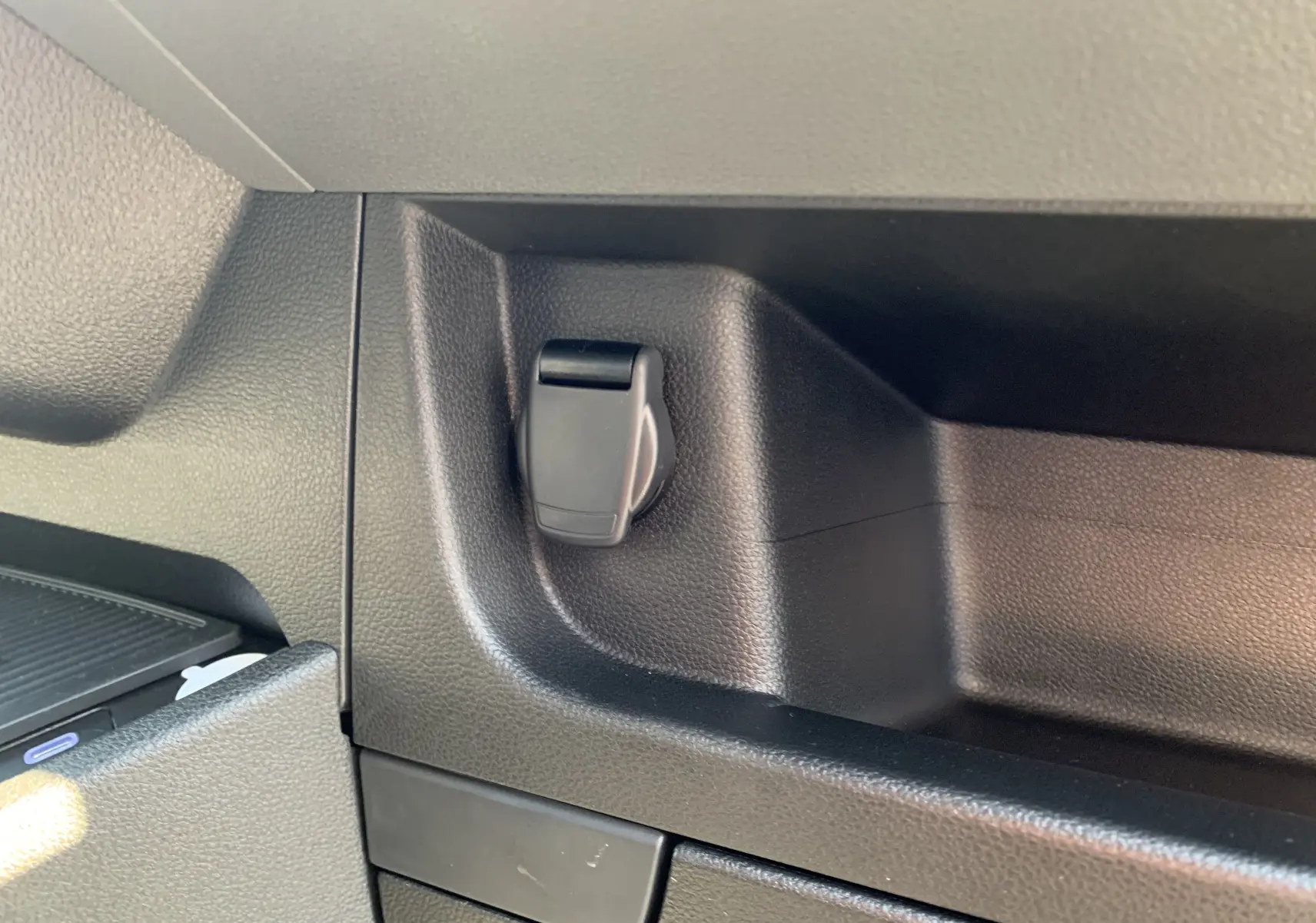 Prise 12V noire intégrée dans la console intérieure du Renault Master blanc mine, vue rapprochée côté droit.