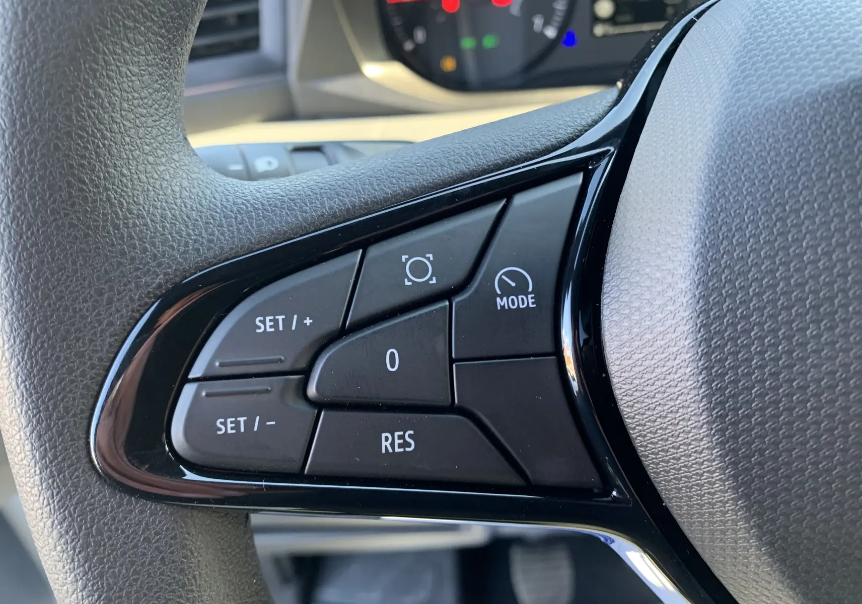 Gros plan sur les commandes de régulateur de vitesse au volant du Renault Master blanc mine 2025.