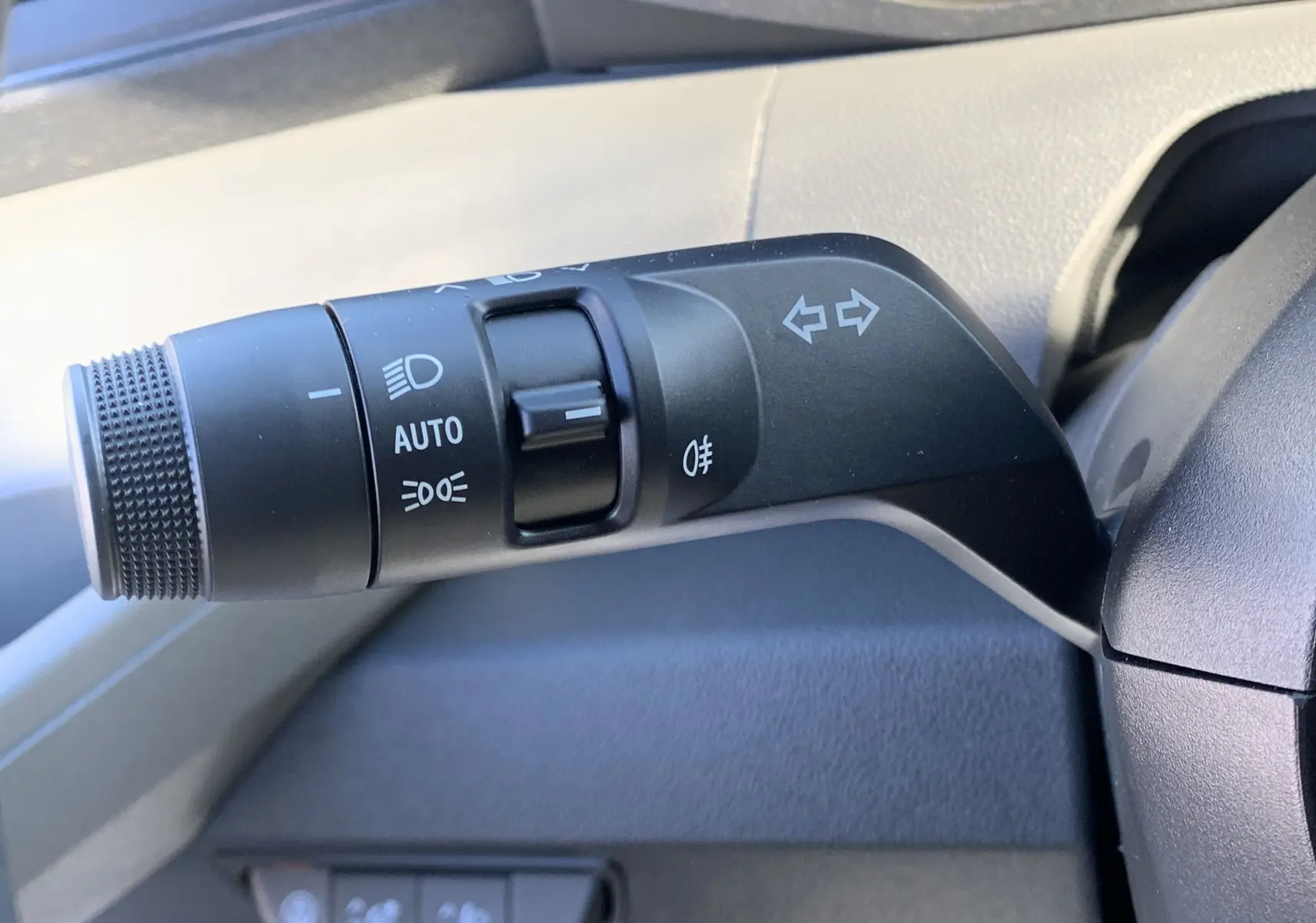 Gros plan sur la manette de clignotants et feux du tableau de bord du Renault Master blanc 2025.