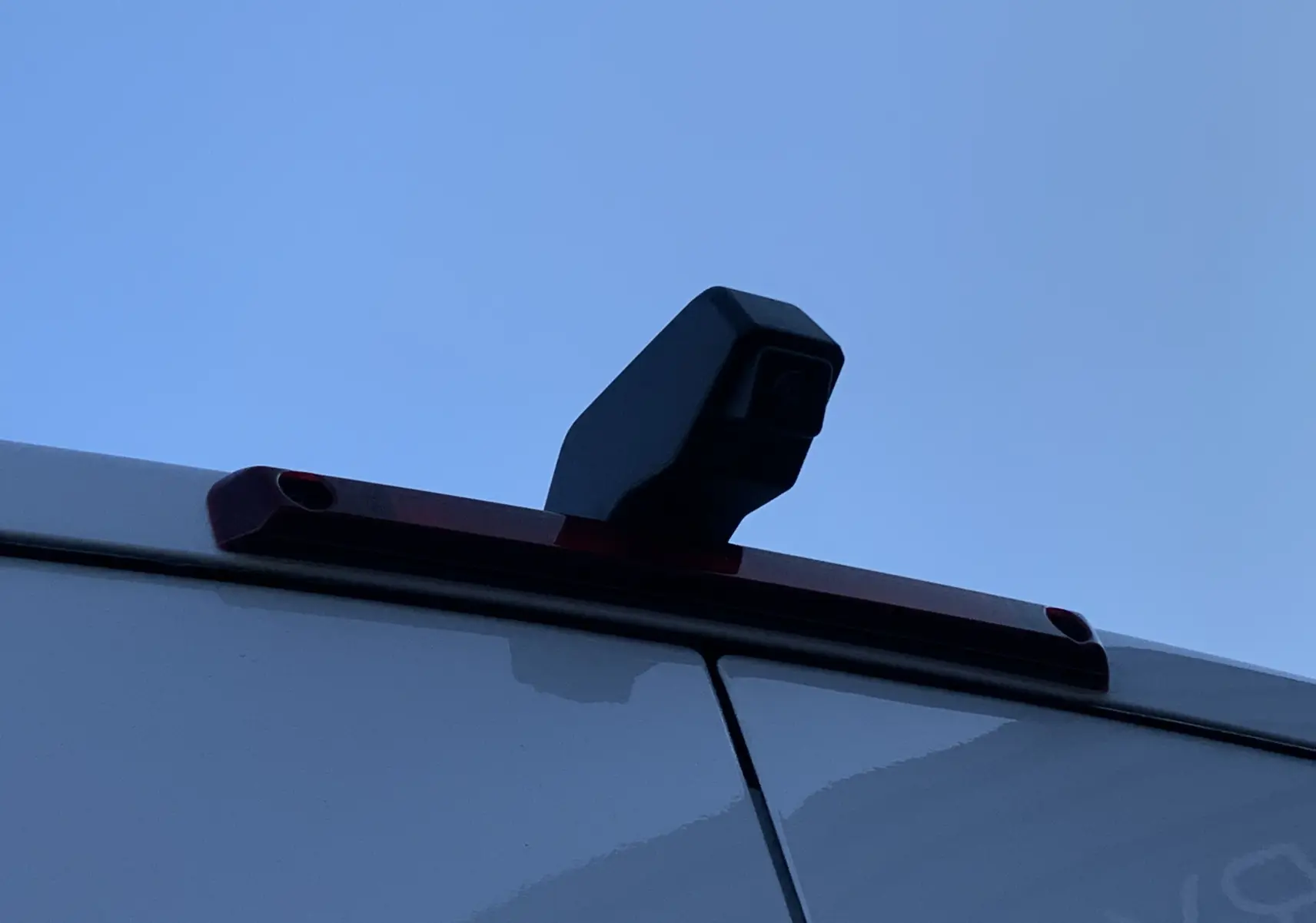 Caméra de recul noire sur la porte arrière blanche d’un Renault Master 2025 vue de près en extérieur.
