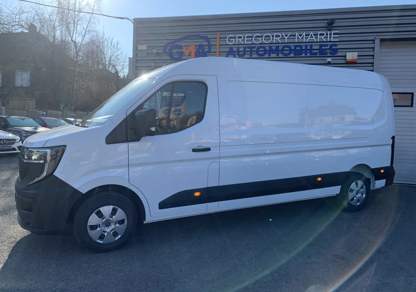 Renault Master blanc minéral vu de profil côté gauche, fourgon utilitaire avec protections noires basses.