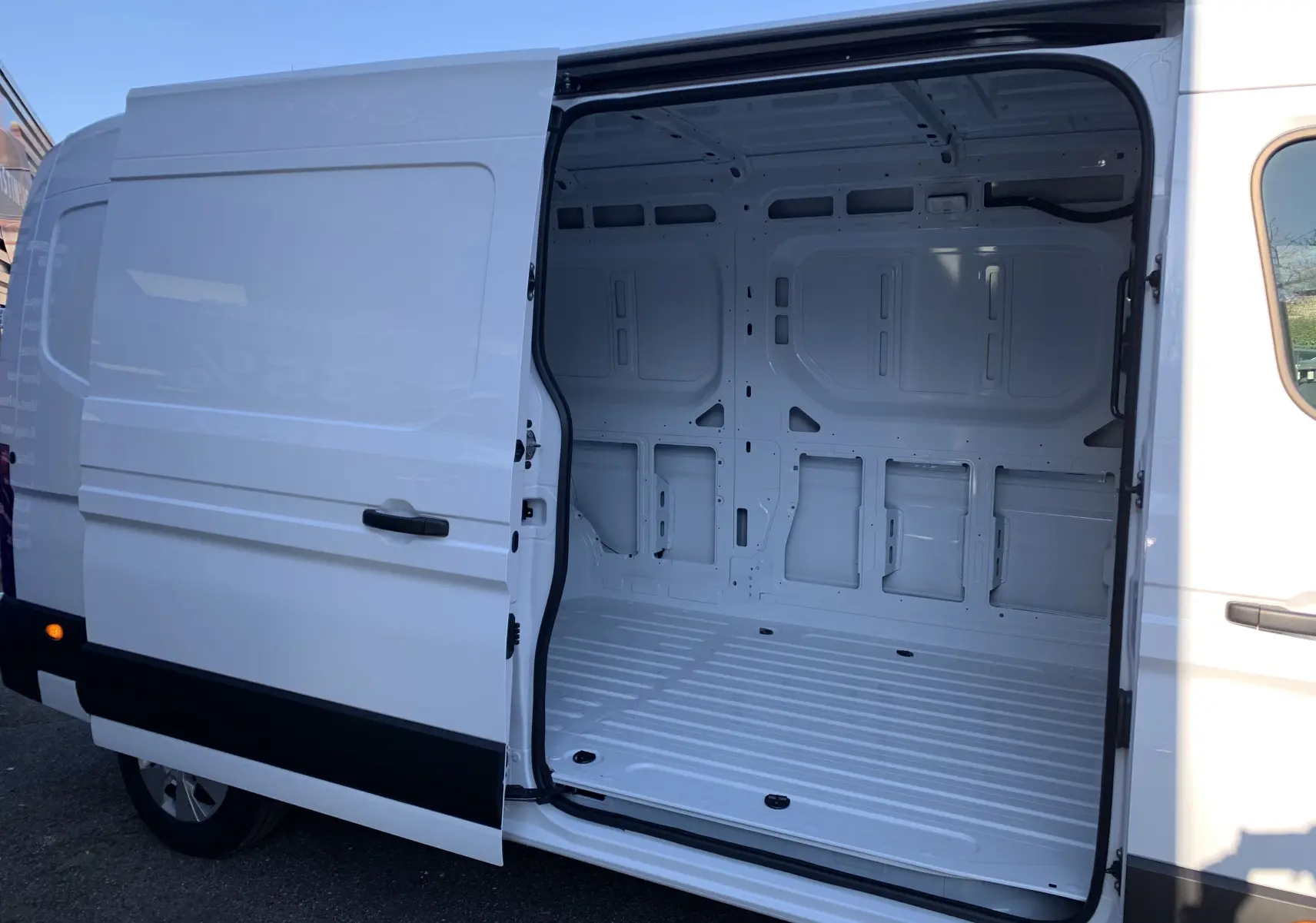 Vue latérale gauche d'un Renault Master blanc mine avec porte coulissante ouverte montrant l'espace de chargement vide