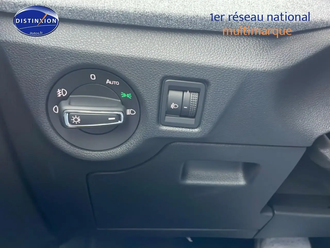 Gros plan sur les commandes d’éclairage côté gauche du tableau de bord d’un Skoda Kamiq noir 2025.