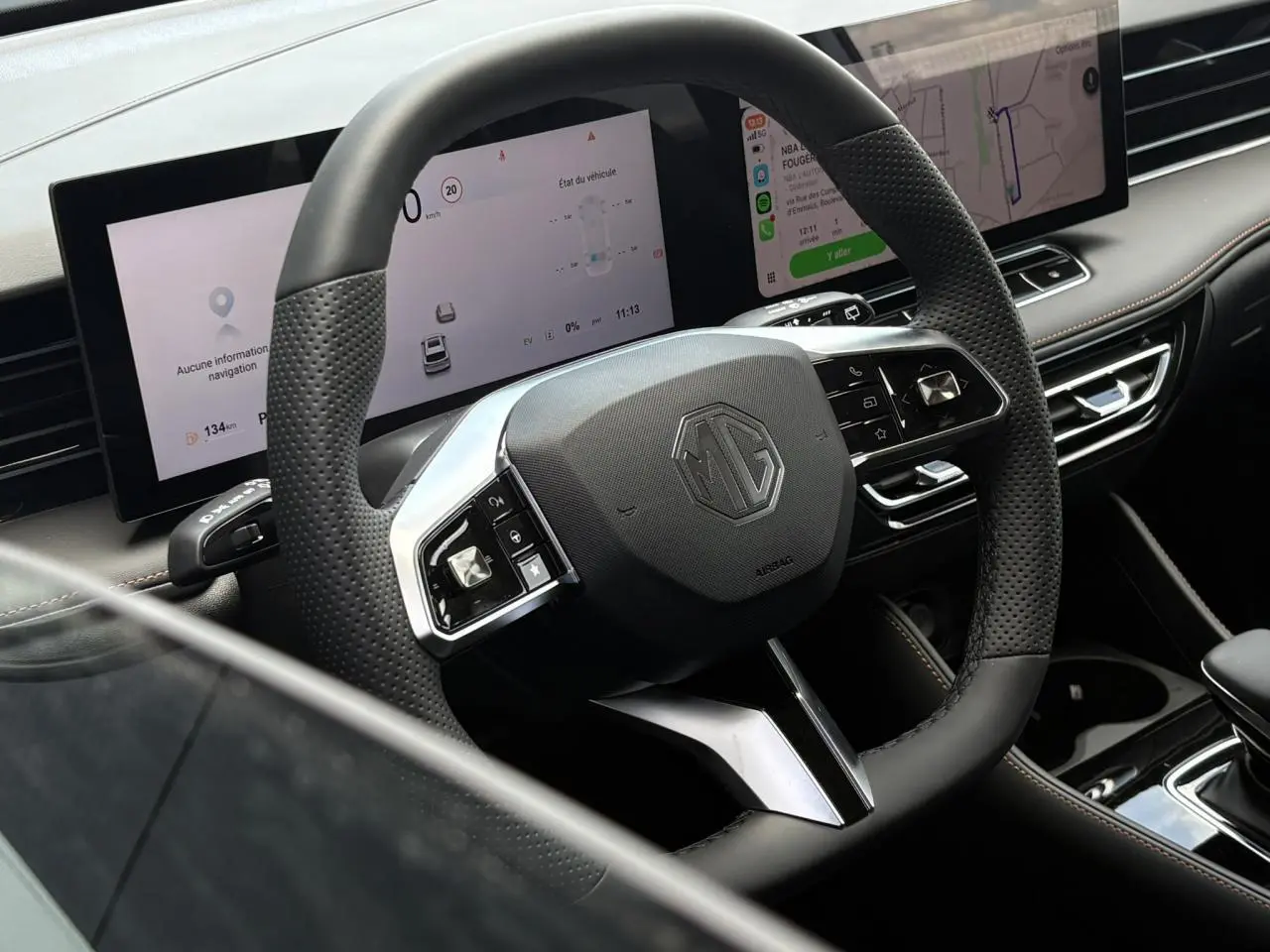 Vue rapprochée du volant noir perforé MG EHS 1.5 Hybrid+ 224 Luxury avec tableau de bord numérique et écran tactile.